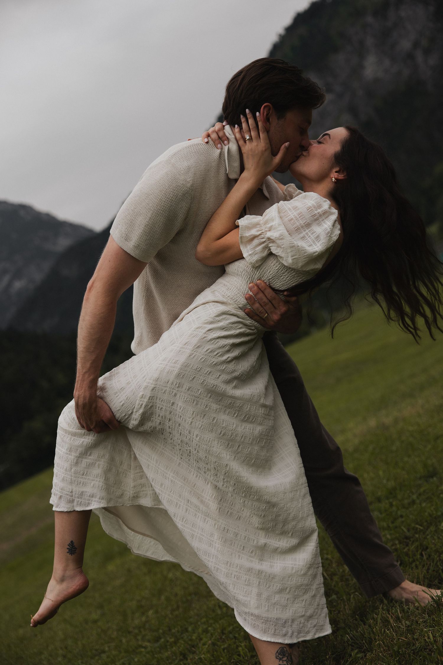 Filmische Aufnahme eines Paares, das sich vor der wunderschönen Alpenkulisse des Thumsees küsst.