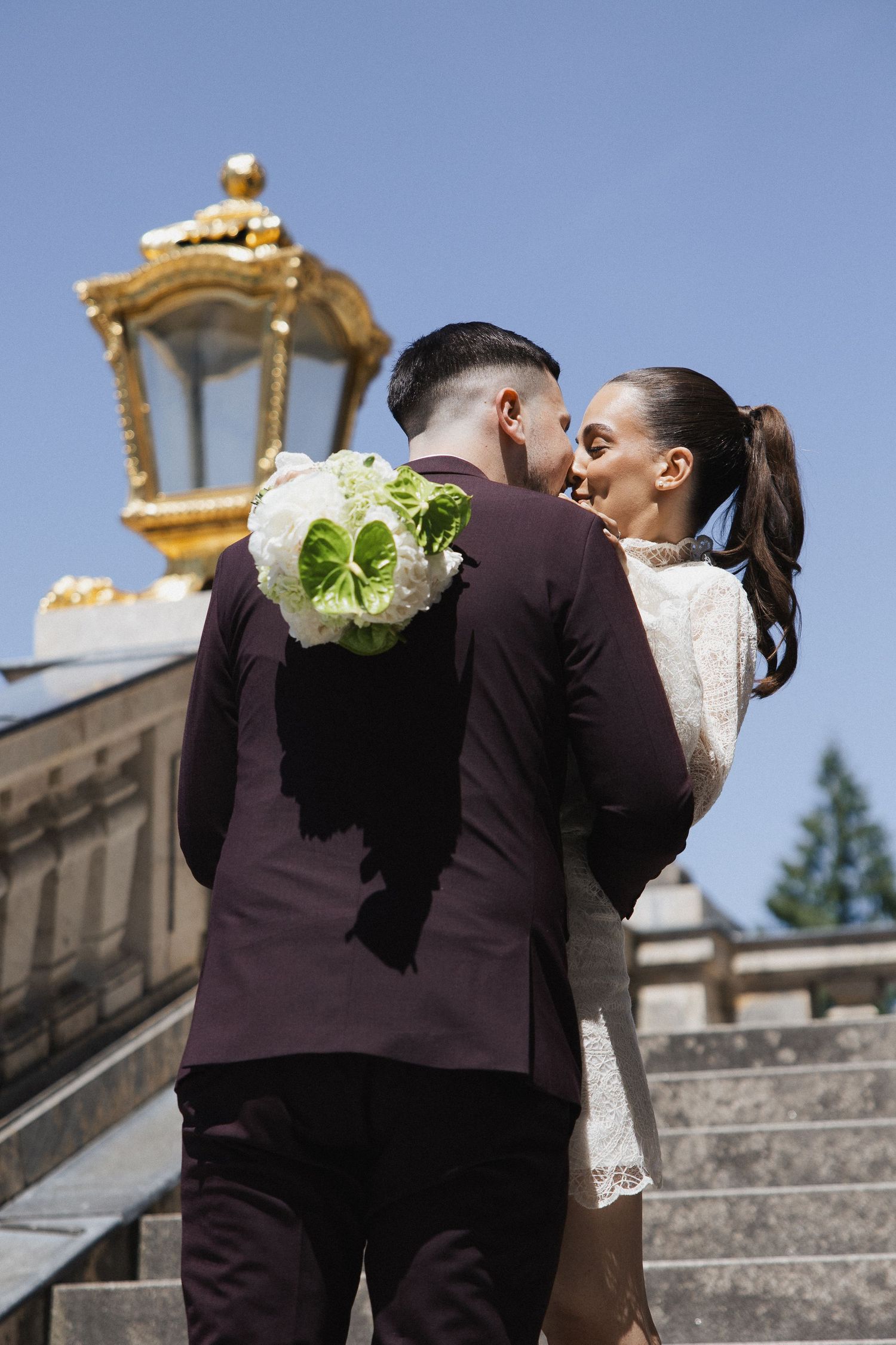 After-Wedding-Fotoshooting Schloss Nymphenburg: Brautpaar küsst sich auf den Schlosstreppen in München. Standesamt Fotografie Bayern.