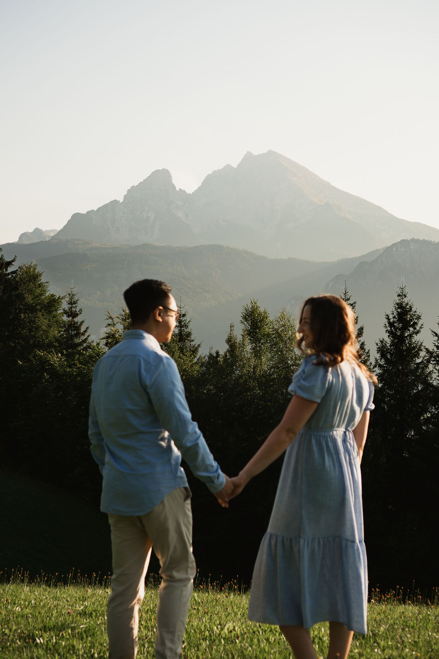 Verlobung in den Alpen: Paar hält Händchen vor Bergpanorama. Fotoshooting Berchtesgaden.