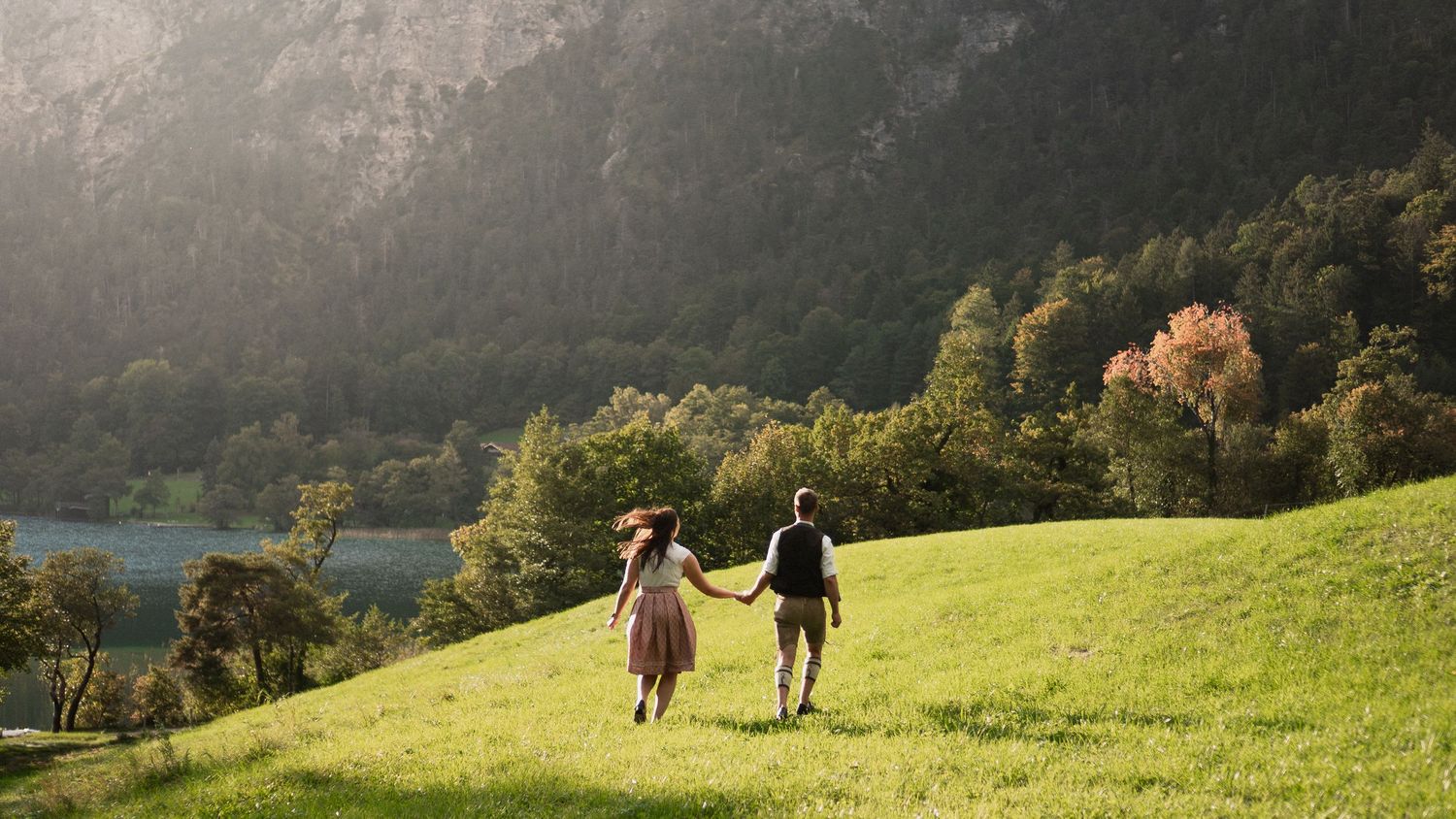 Trachtenhochzeit am Hintersee: Kuss vor Bergkulisse. Hochzeitsfotograf Berchtesgaden.