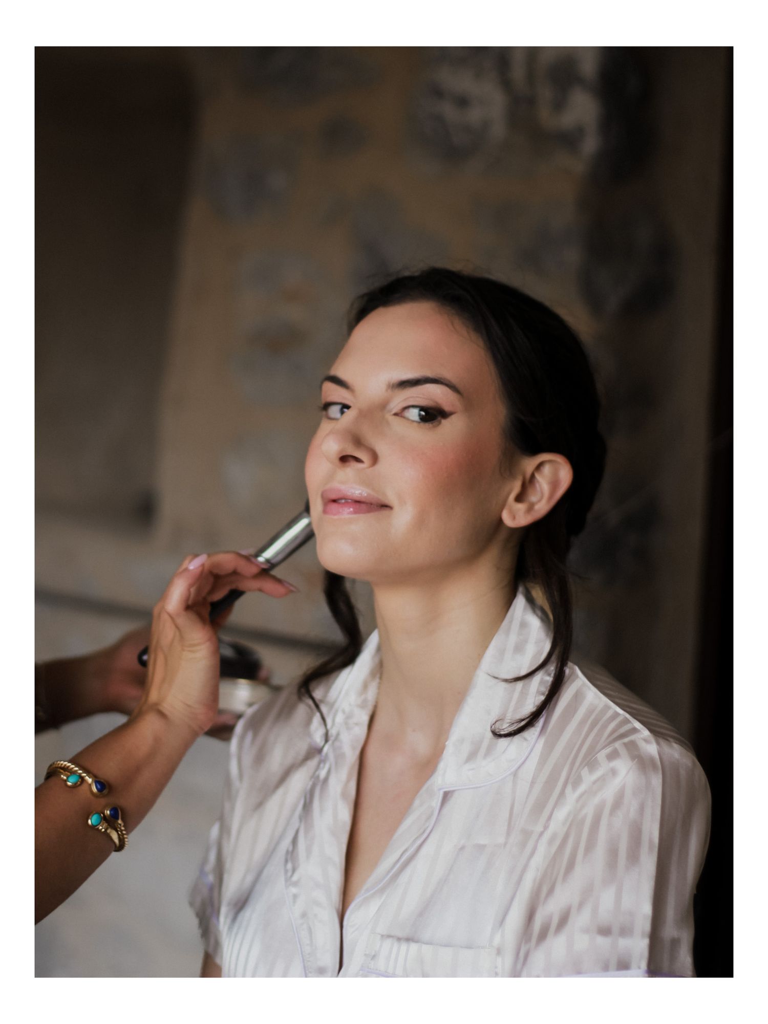 Hochzeits-Beauty-Shot: Detailaufnahme der Visagistin beim Verblenden des Make-ups für die strahlende Braut in Marmari.