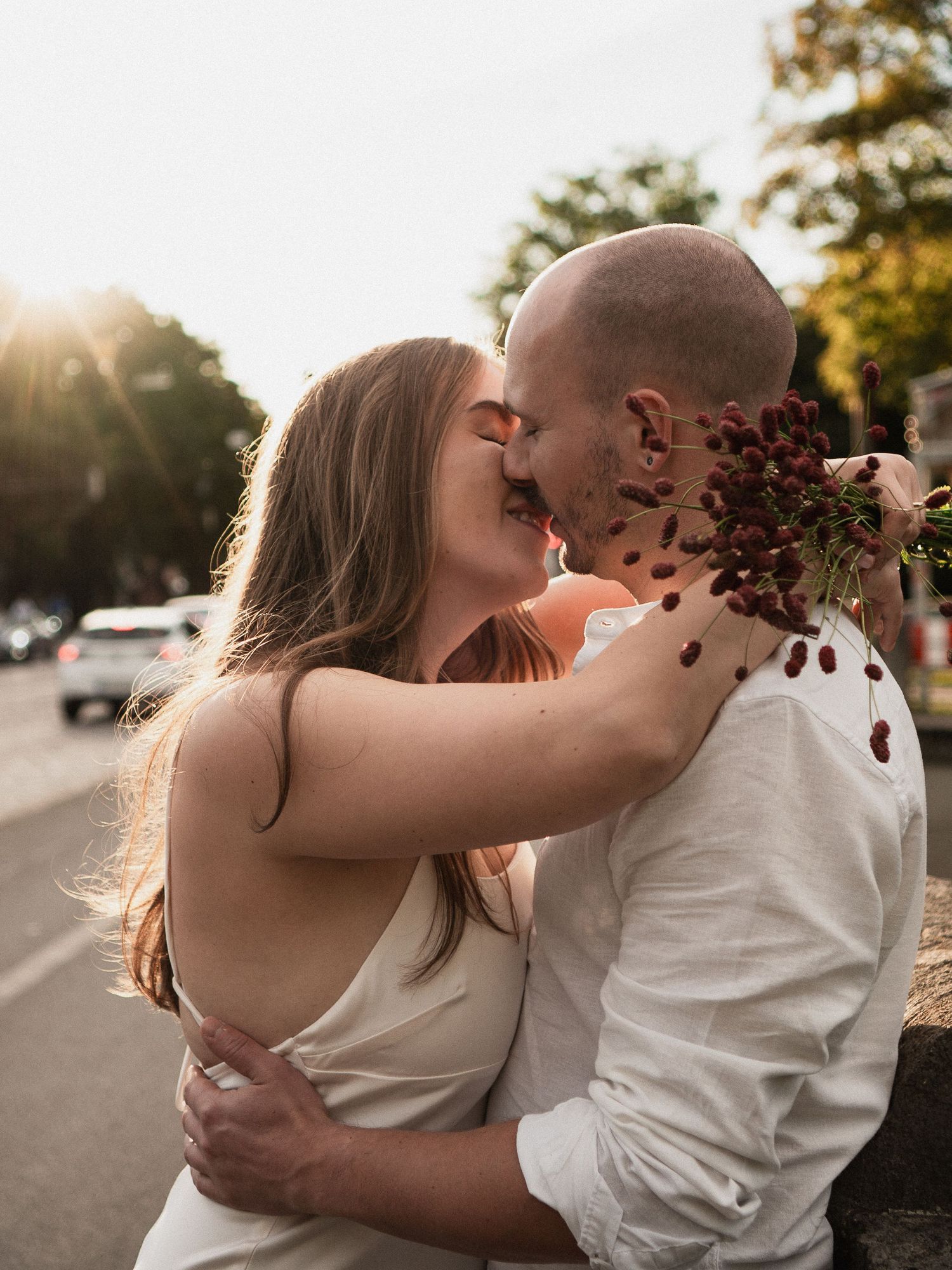 Urban Wedding Vibes: Paar küsst sich auf der Maximilianstraße in München bei goldenem Gegenlicht und herbstlicher Atmosphäre.