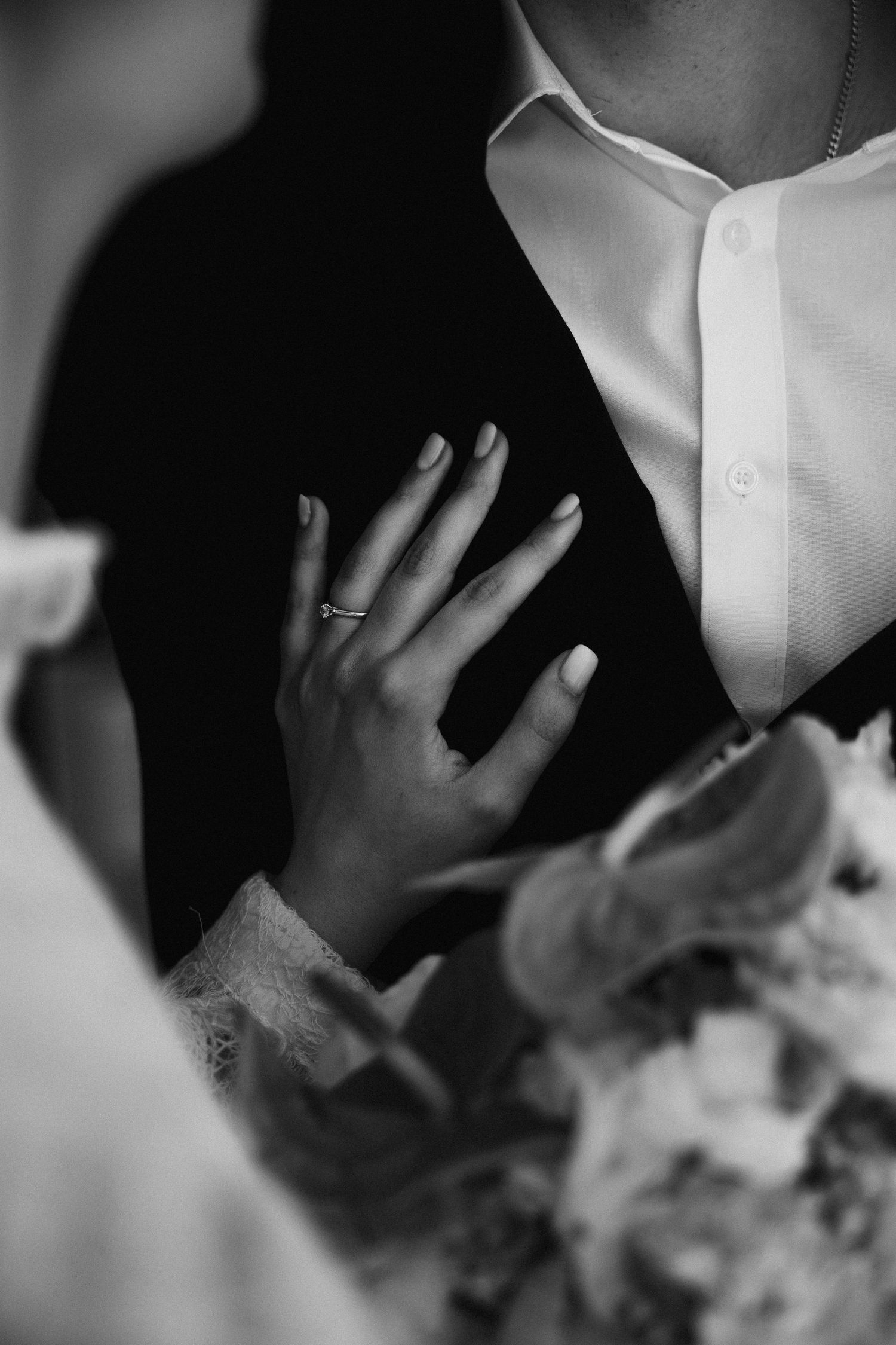Detail After-Wedding-Shoot Schloss Nymphenburg München: Ehering & Brauthand auf der Brust des Bräutigams, Schwarz-Weiß Hochzeitsfotos.