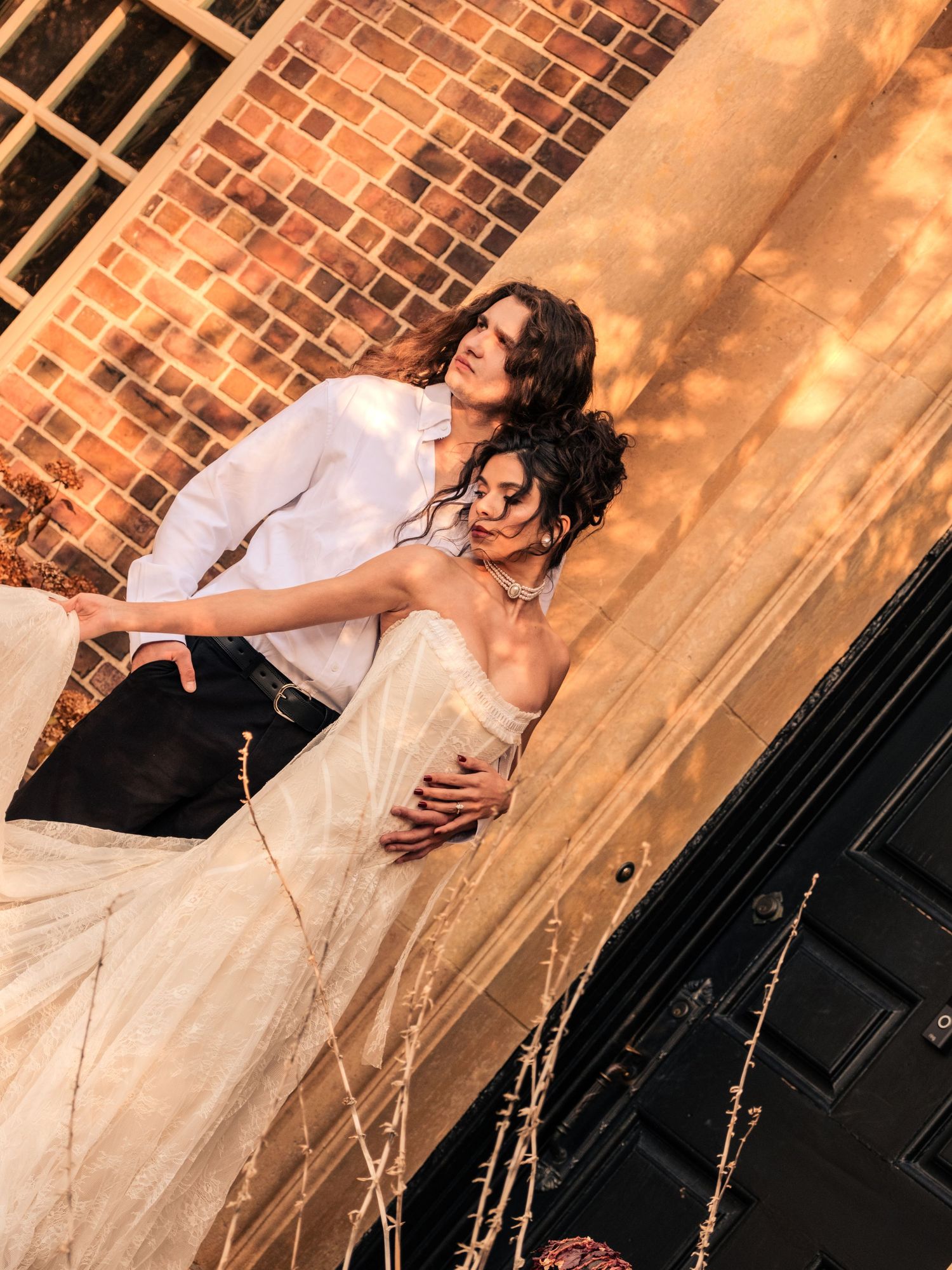 A performer in a white dress strikes dramatic poses against a brick wall in a series of artistic performance shots.