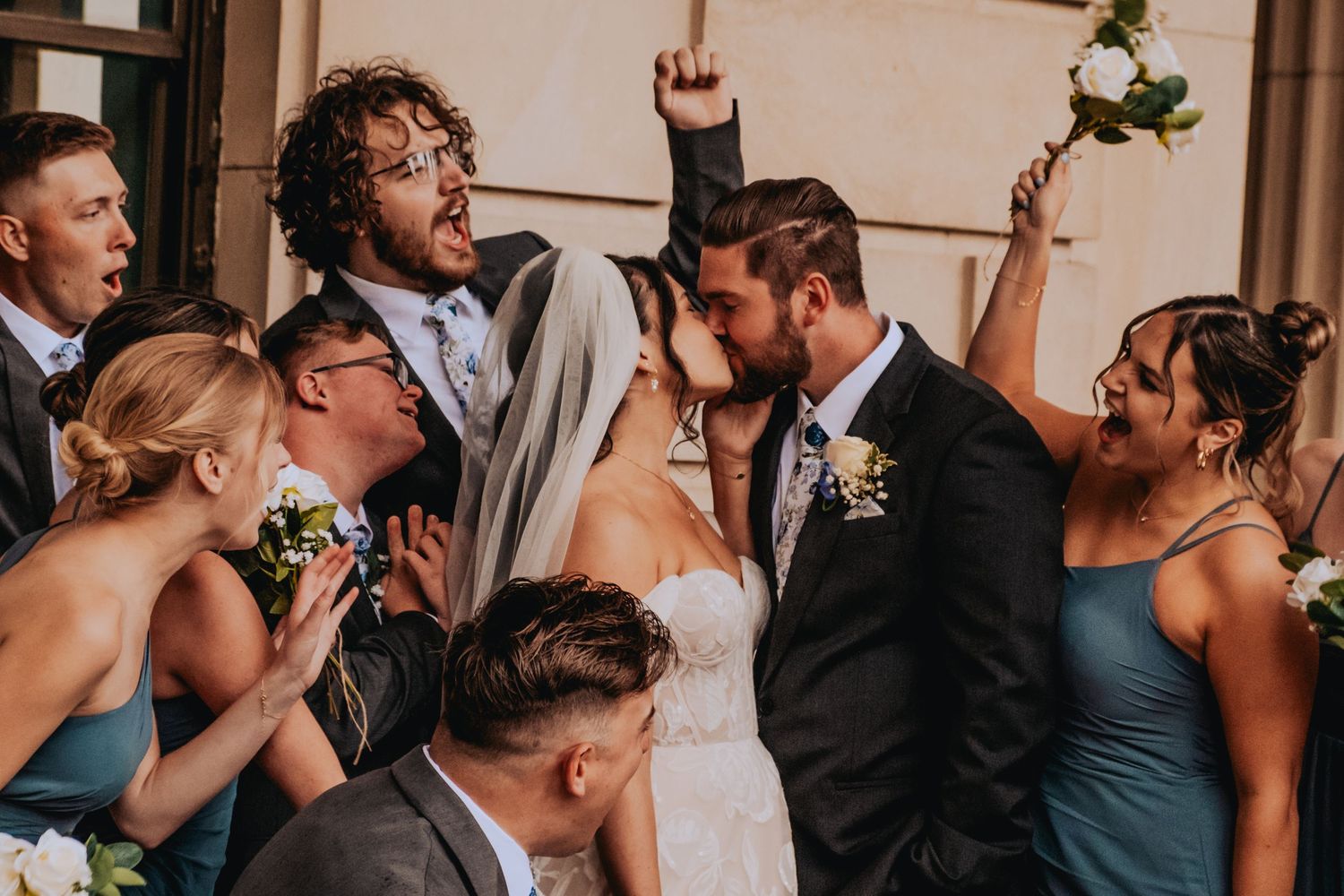 A wedding party celebrates with joyful embraces and kisses in a series of candid reception moments.