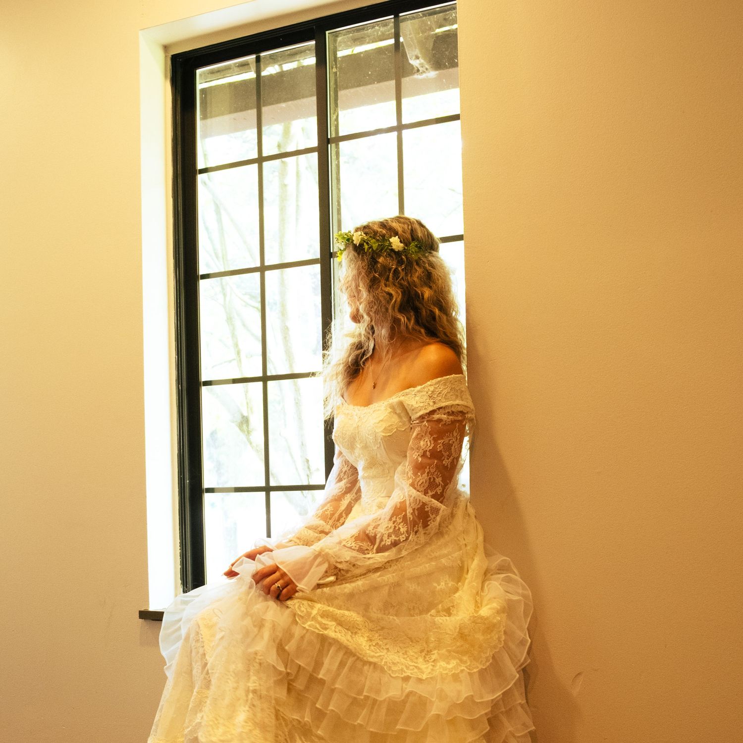Ethereal bridal portrait series showing flowing white dress and veil in soft golden window light.