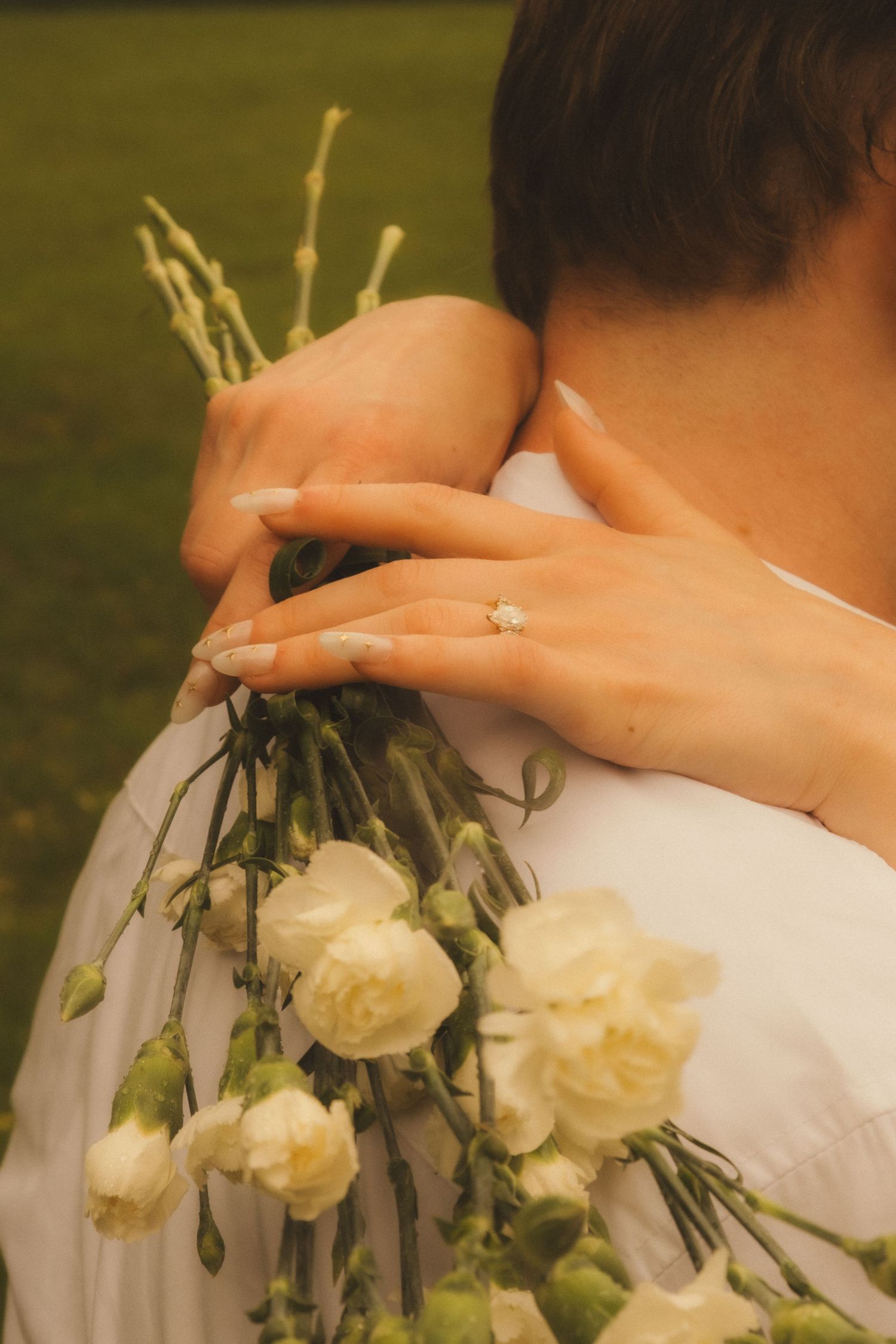 A close-up sequence showing white roses and greenery decorating the back of a white wedding dress.