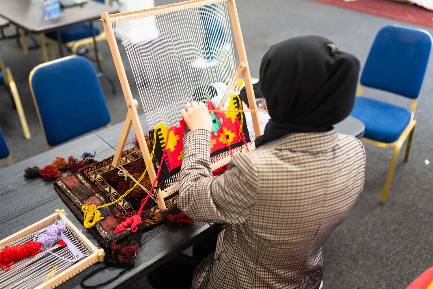 A woman weaving a mat
