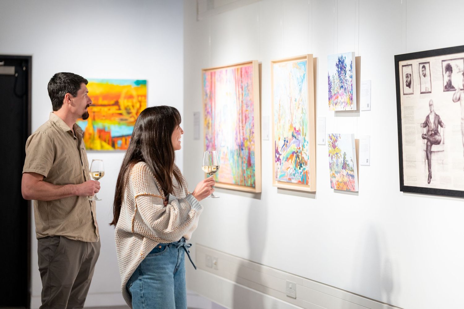 Two people looking at art on a wall