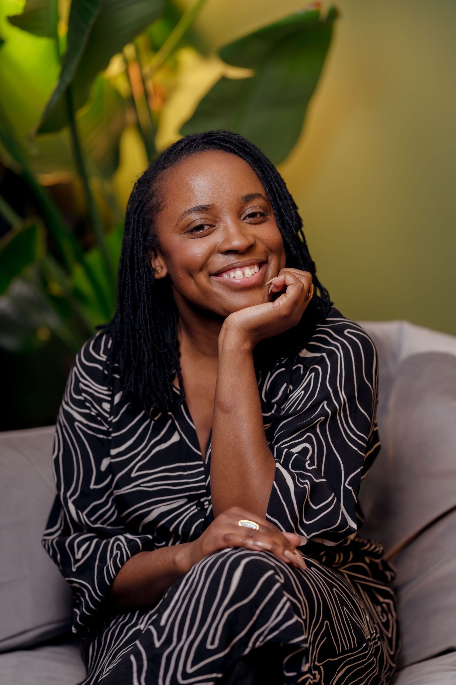 A portrait of a black woman cradling her chin in her palm