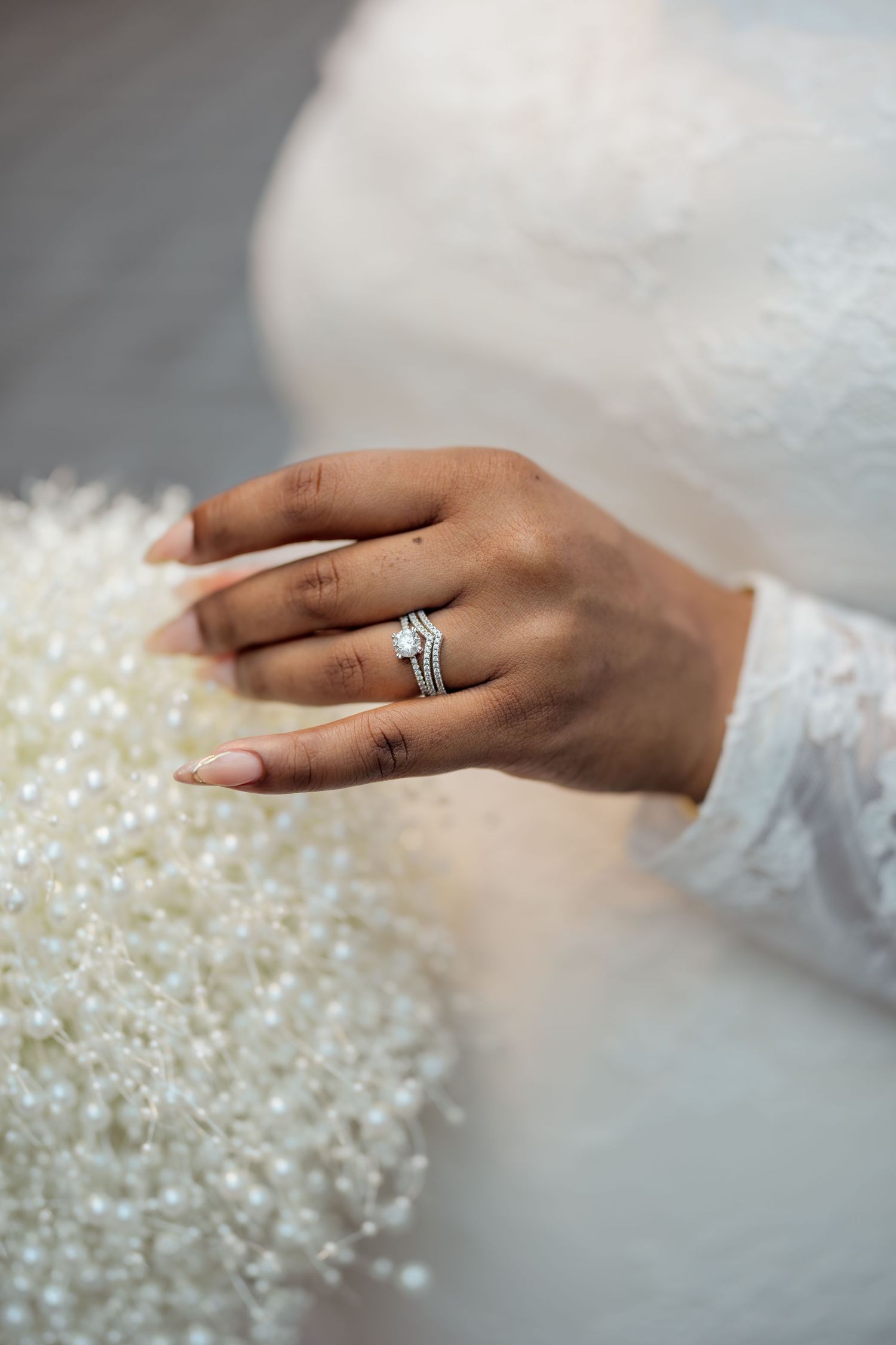 A bride's hand with the ring touching the bouquet