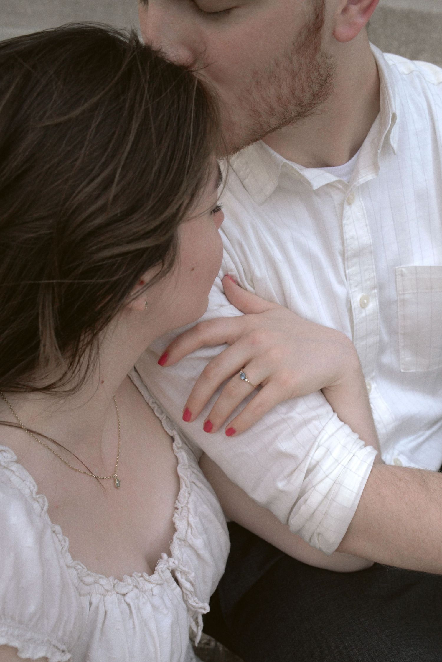 A romantic monochromatic photo sequence showing an intimate moment between two people in white clothing.