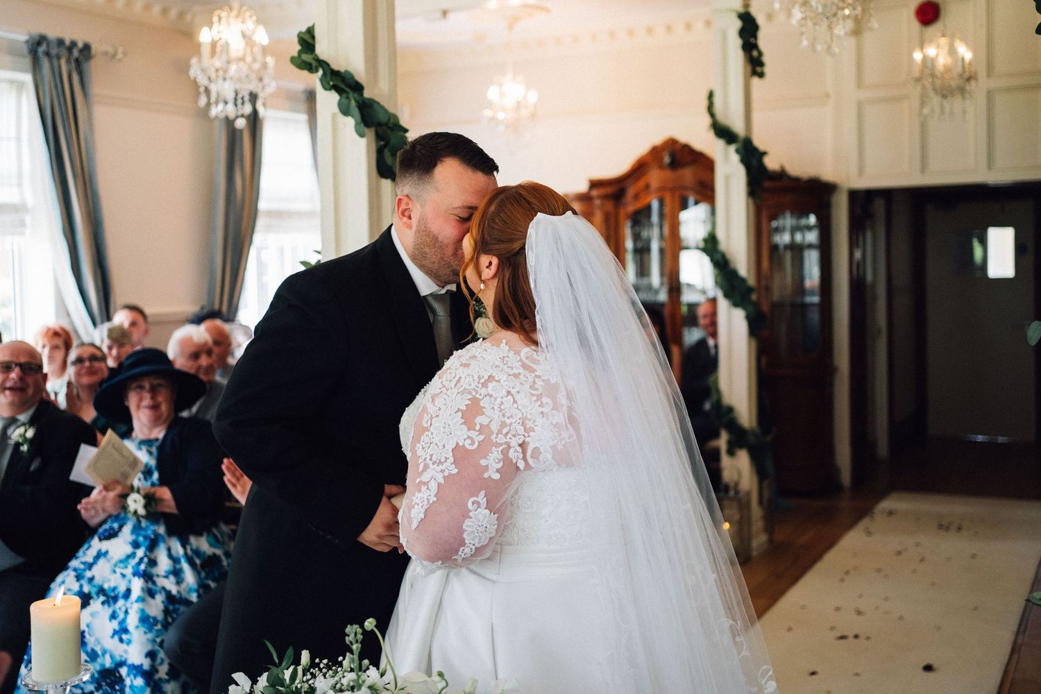 A romantic wedding reception moment captured in an elegant ballroom with chandeliers and string lights.
