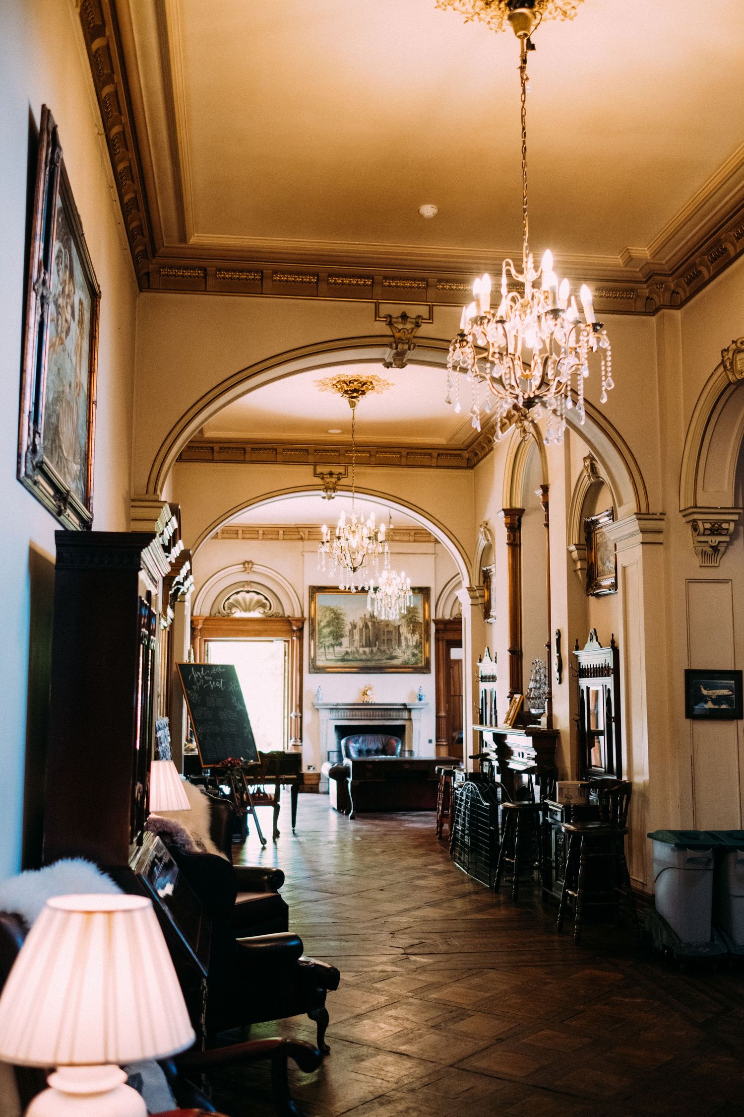 Elegant ballroom interior with crystal chandeliers and arched hallways in a historic venue.