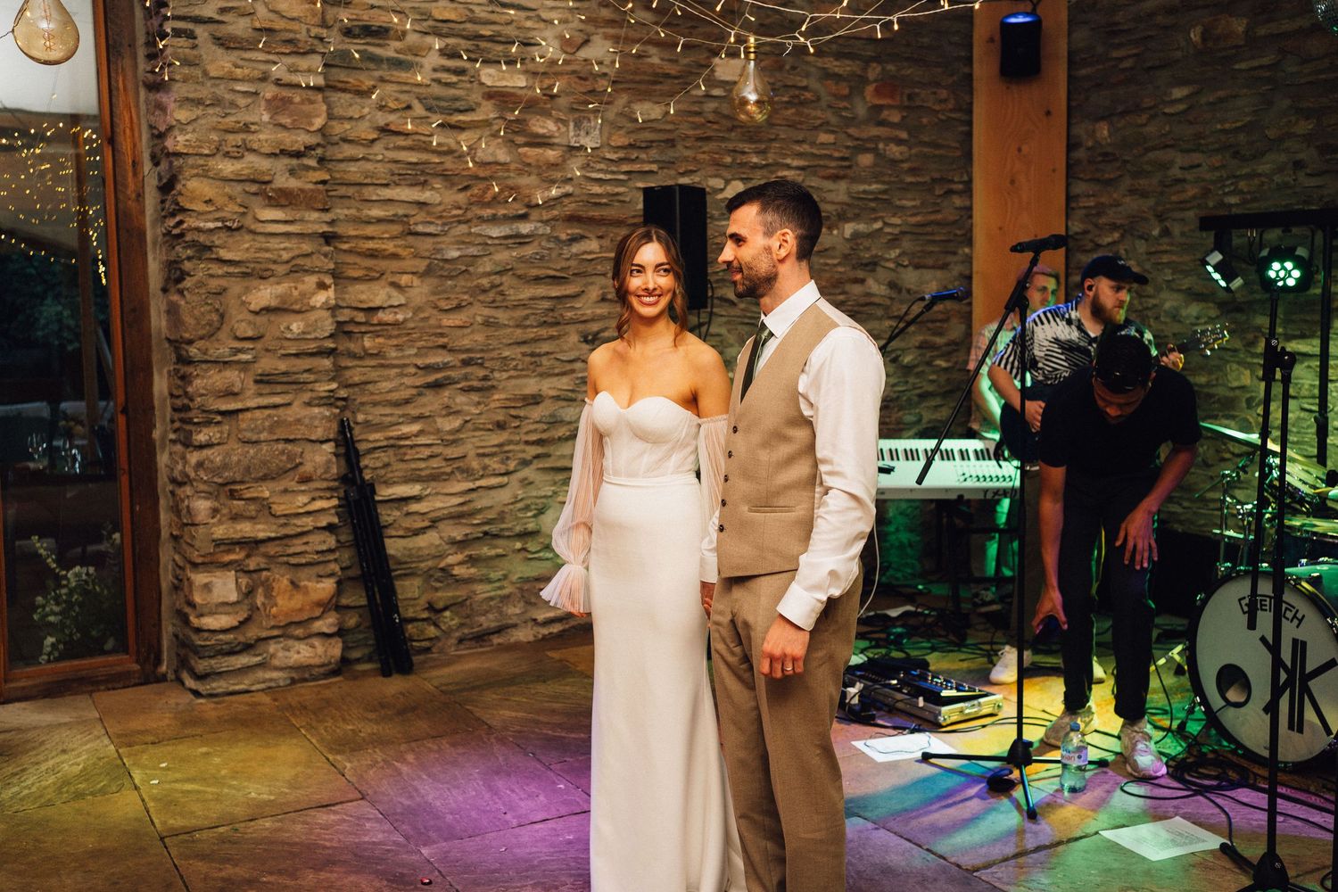 A wedding reception venue with stone walls and string lights creating a romantic atmosphere.