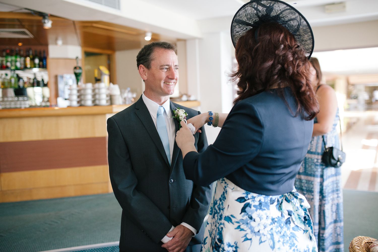Candid reception moments captured between guests in an indoor venue.