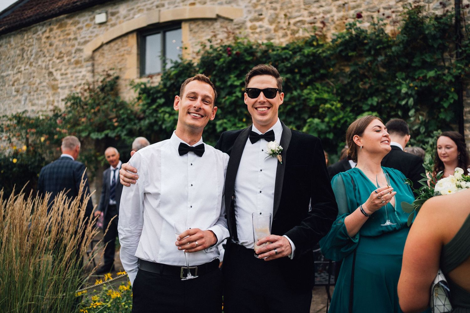 Elegant wedding reception gathering outside historic stone building.