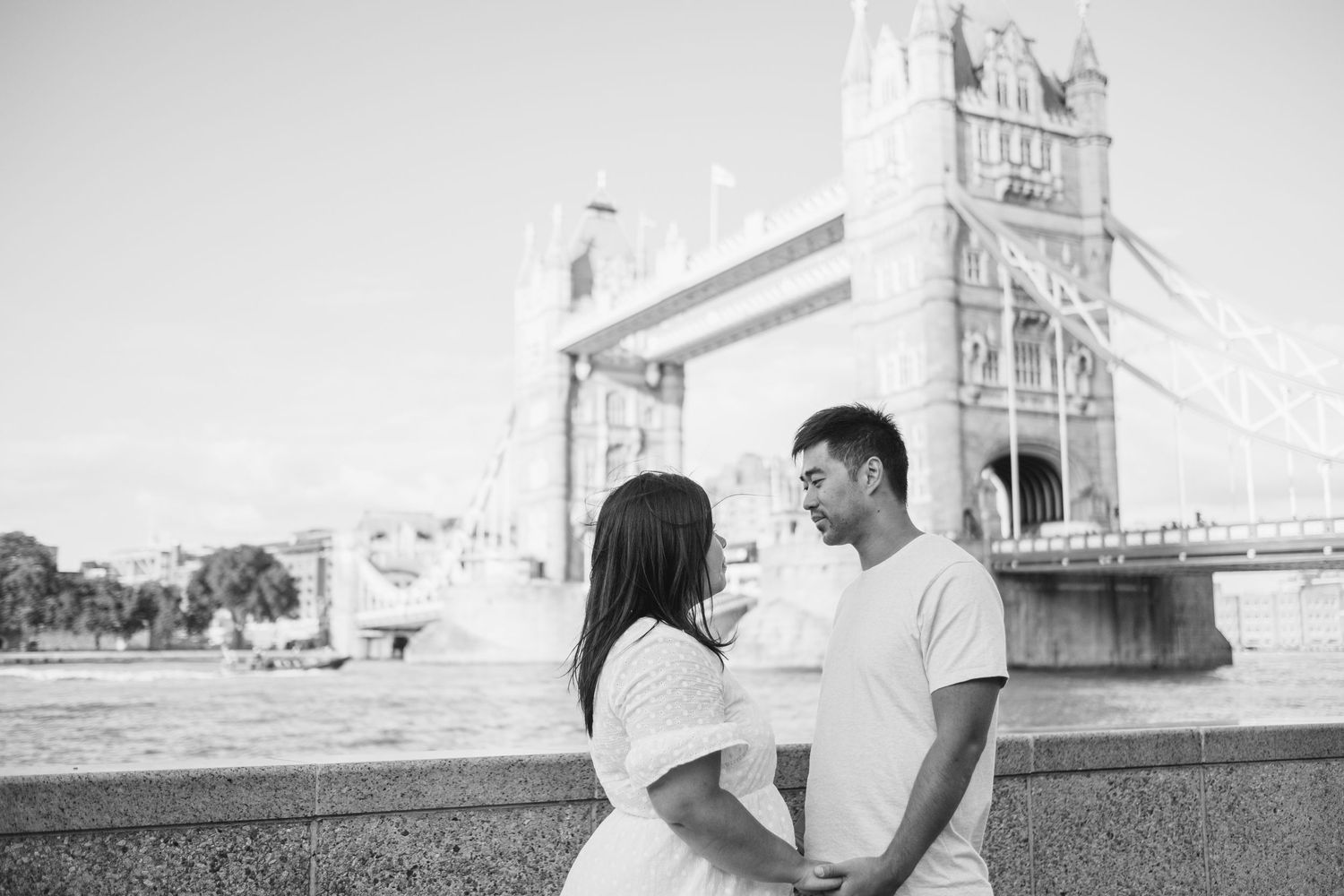 Tower Bridge looms majestically in the background as people enjoy the London riverside.