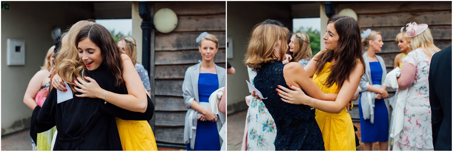 Wedding guests embracing and socializing at an outdoor reception.