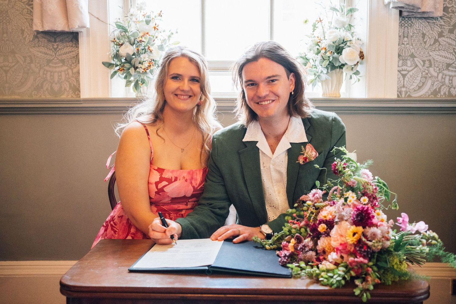 A couple shares a tender moment on elegant marble stairs during their wedding celebration.