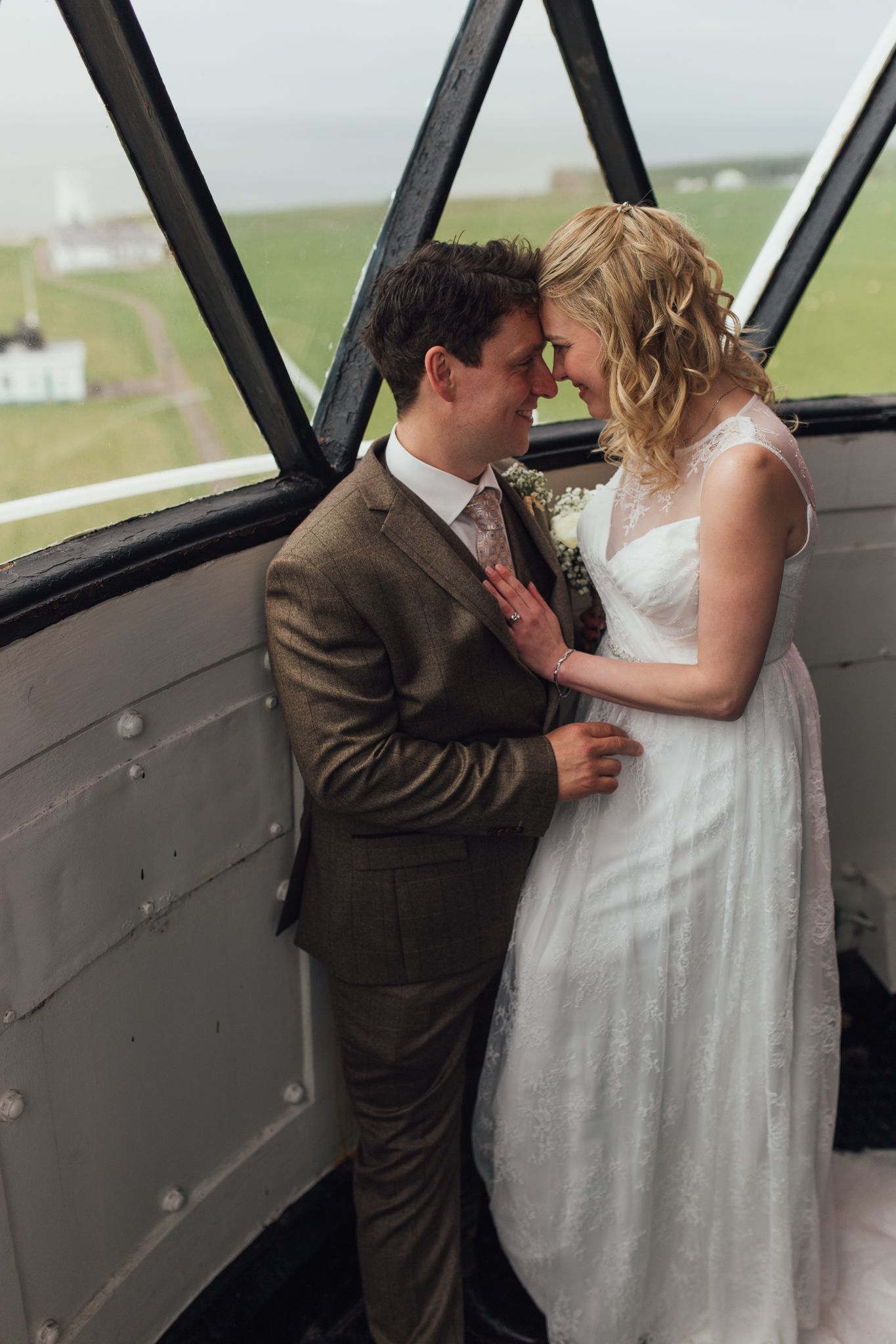 Romantic moment between newlyweds in vintage aircraft interior.