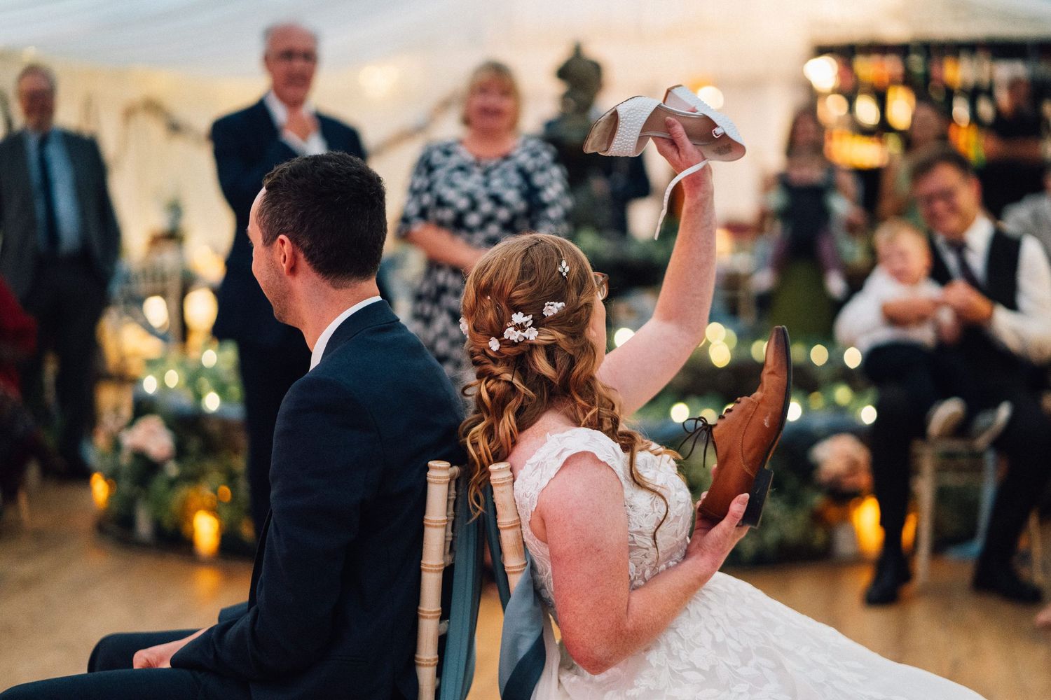 Wedding party members dance and celebrate during a sunset reception outdoors.