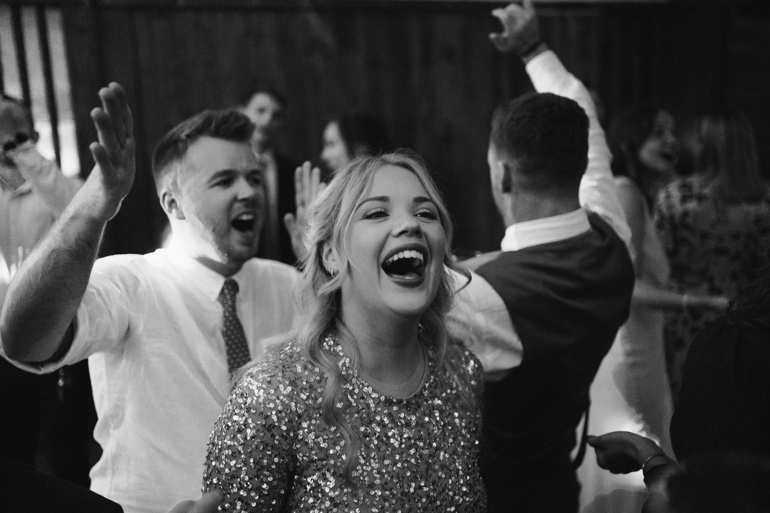 A black and white photo collage showing wedding reception guests dancing and celebrating at a party.