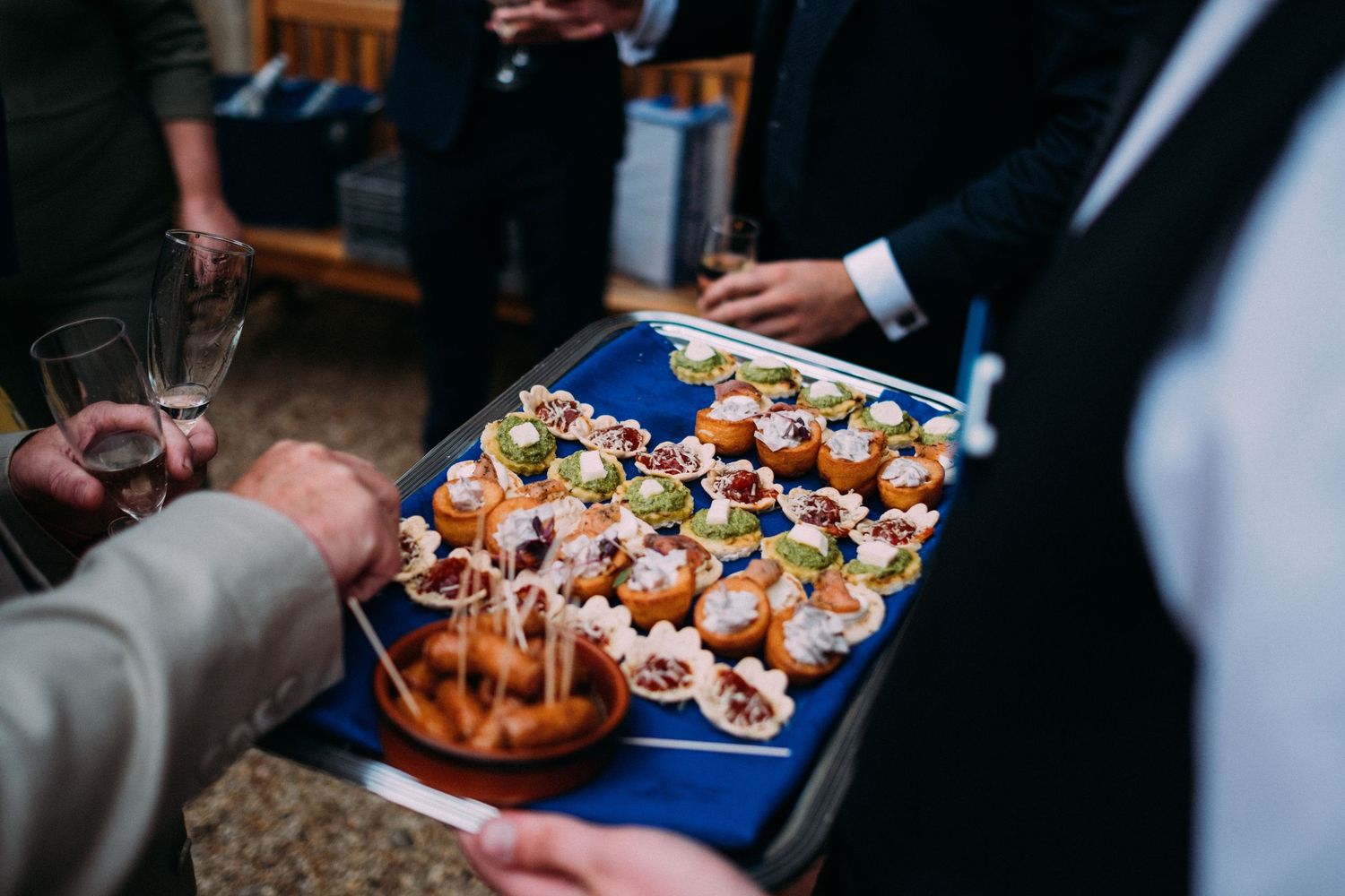 Wedding reception appetizers being served on decorative platters.