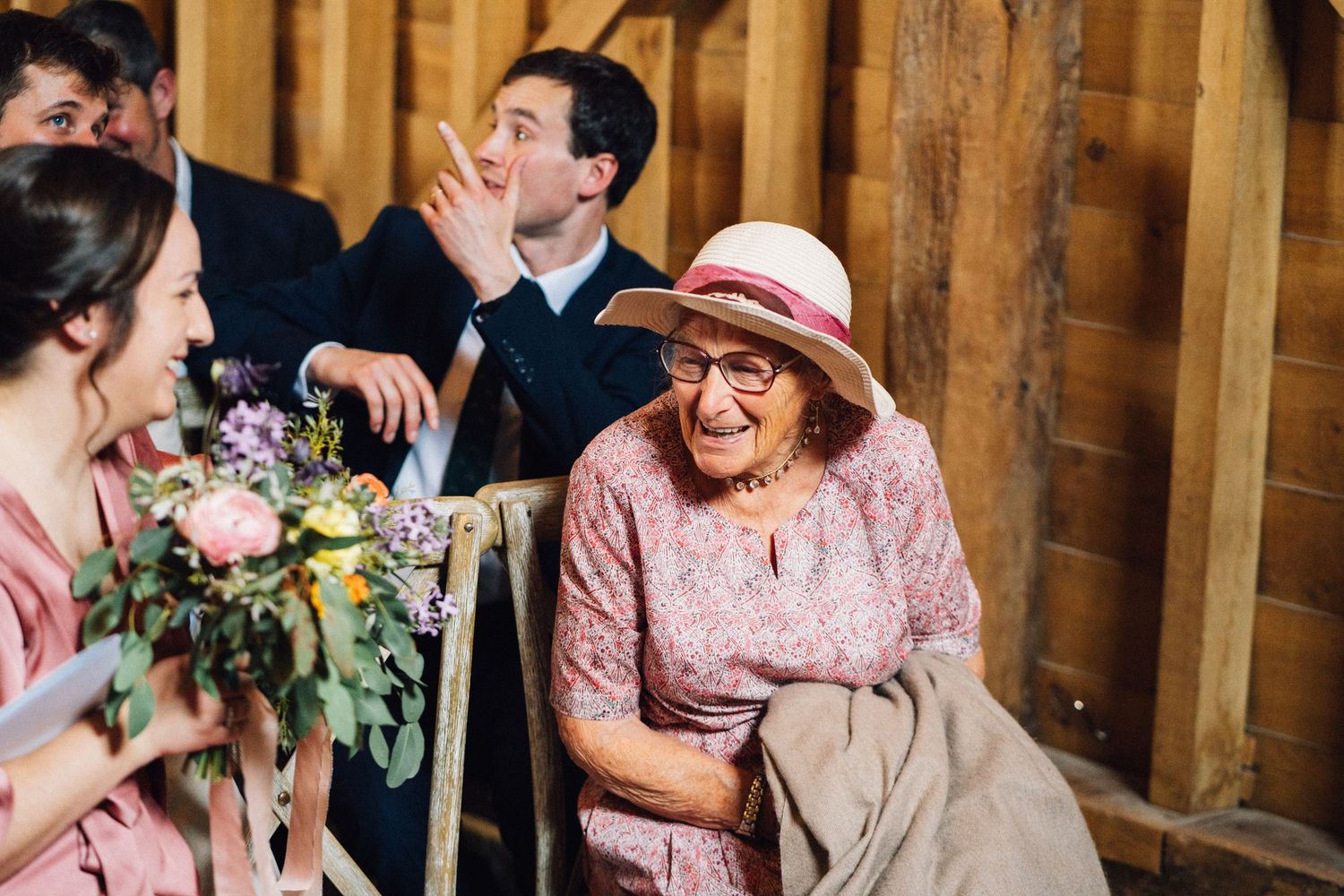 Guests celebrating during a rustic barn wedding with warm lighting and decorative elements.