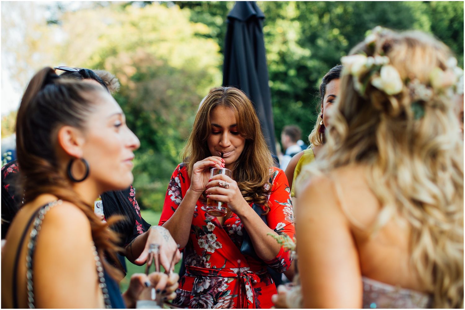 Wedding guests laughing and socializing at an outdoor reception.