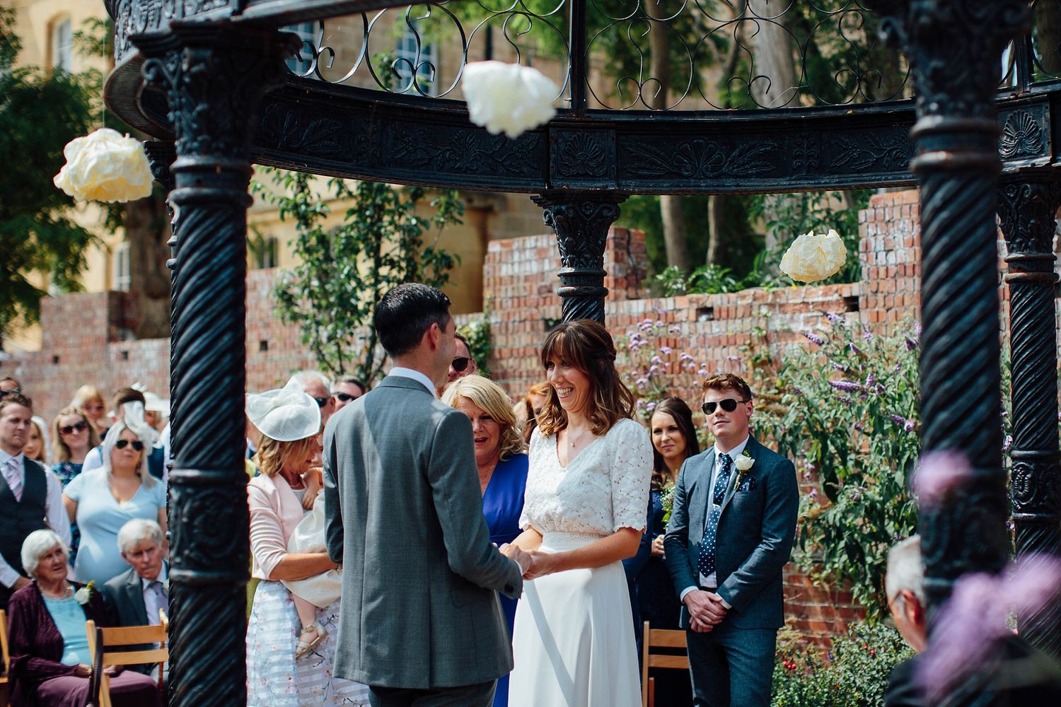 Garden wedding ceremony setup with decorative pillars and natural greenery.