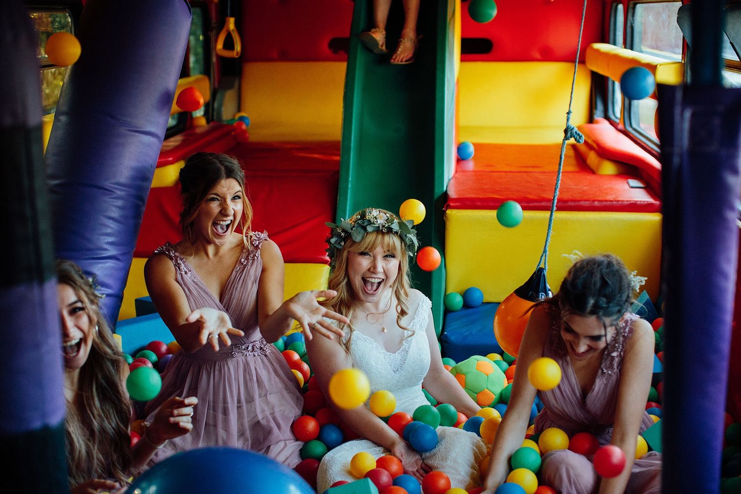 Colorful indoor play area with balloons and inflatable decorations.