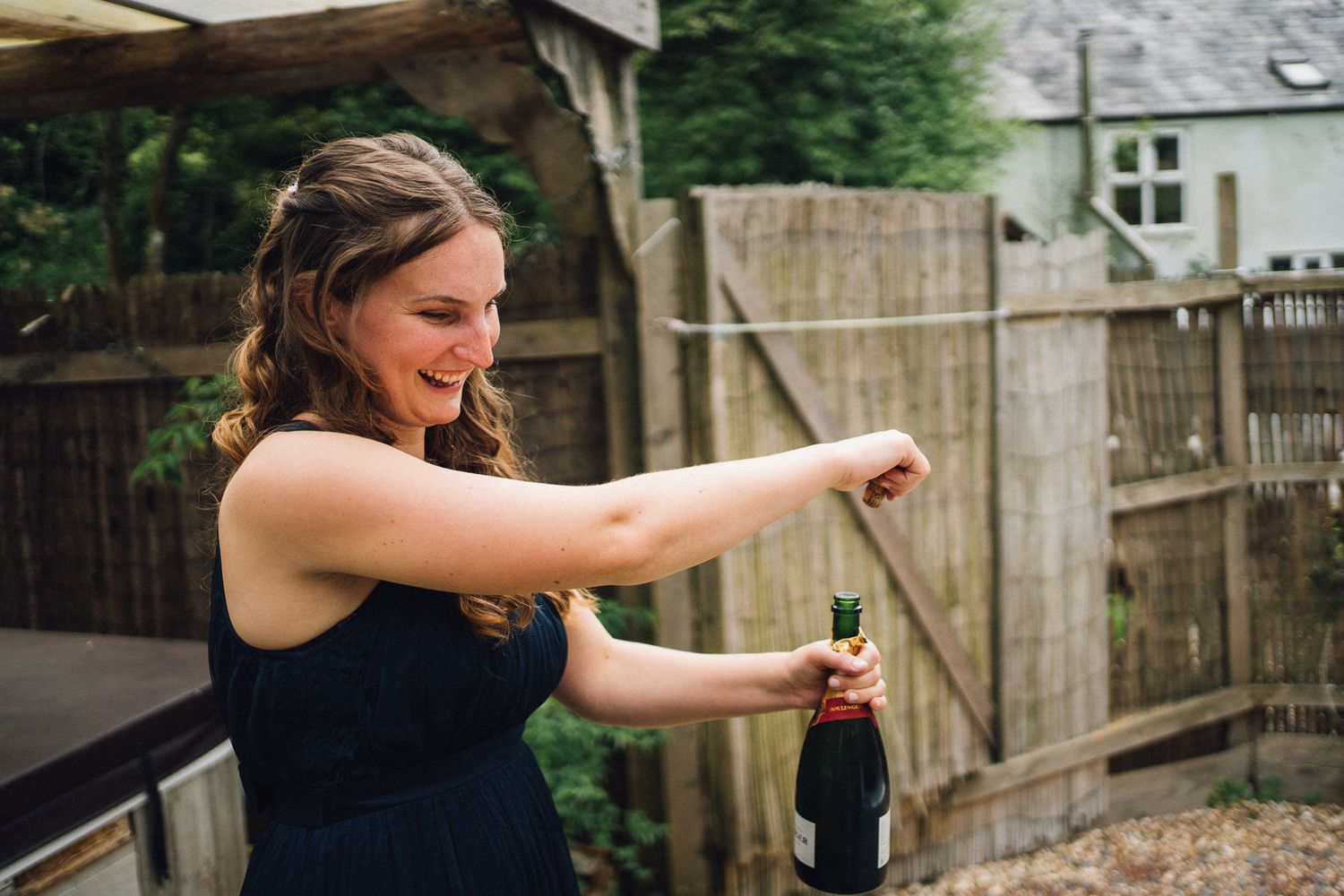 Wedding party members dancing and celebrating outdoors in a backyard setting.