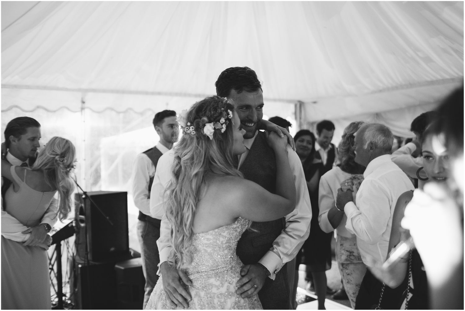 Couples dancing together during a wedding reception in a white tent venue.