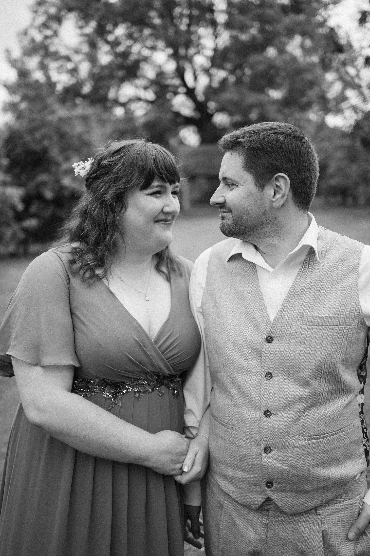 A romantic black and white photo series showing a couple embracing and sharing tender moments outdoors.