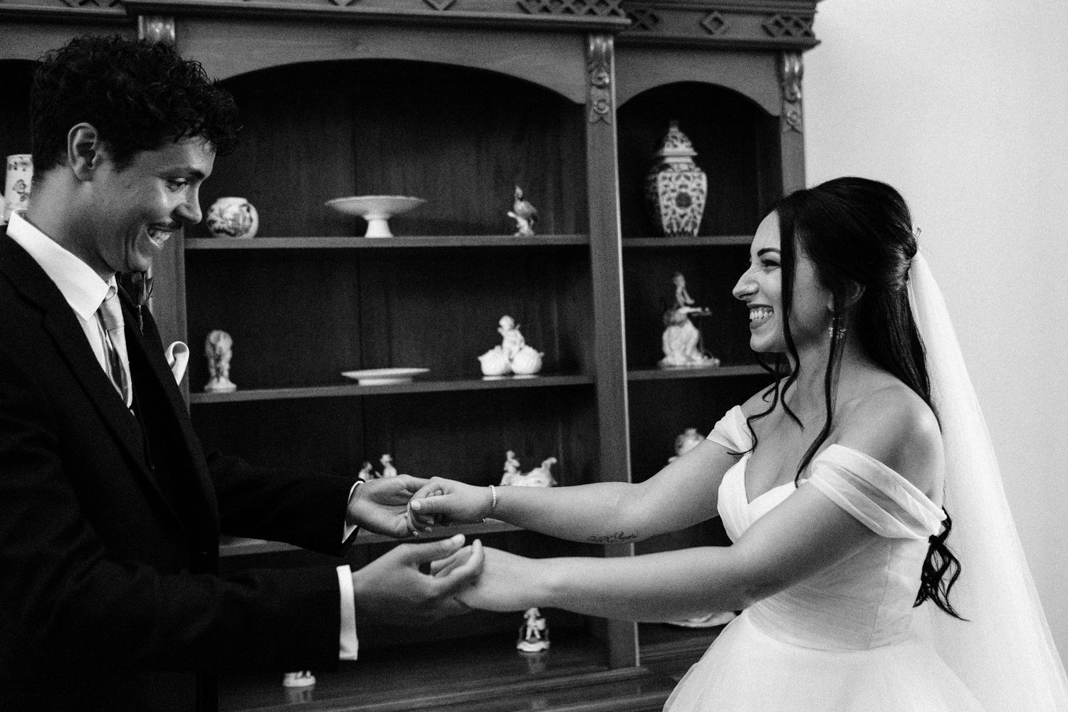 Romantic couple dancing in an elegant room with decorative shelving.