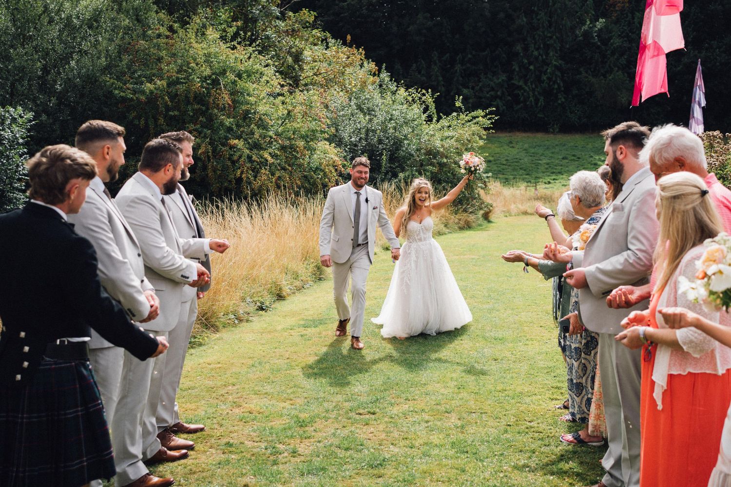 Wedding couple walks down the aisle as guests form lines on either side.