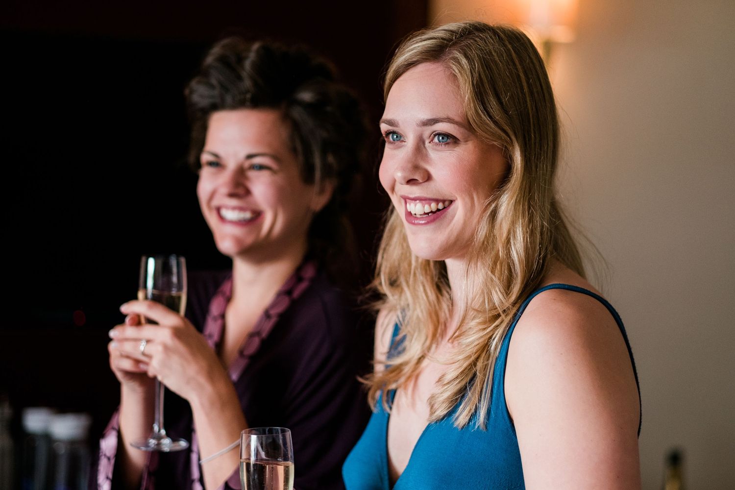 Wedding party guests enjoying drinks and conversation at an evening reception.