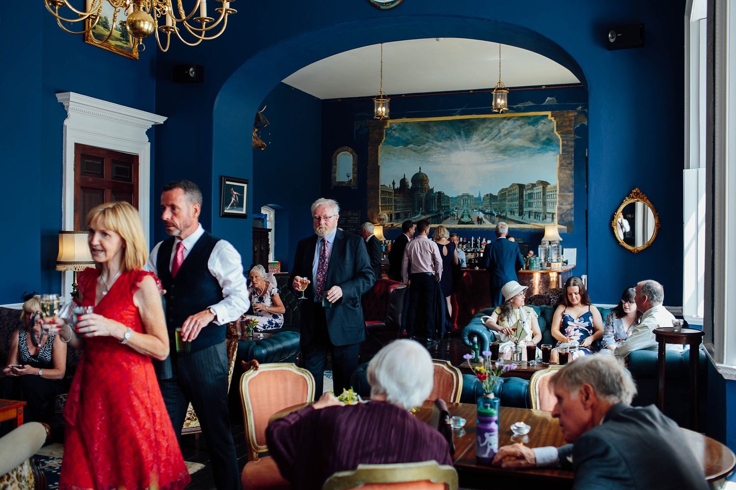 Elegant reception venue with navy blue walls and chandelier lighting creates an intimate atmosphere.