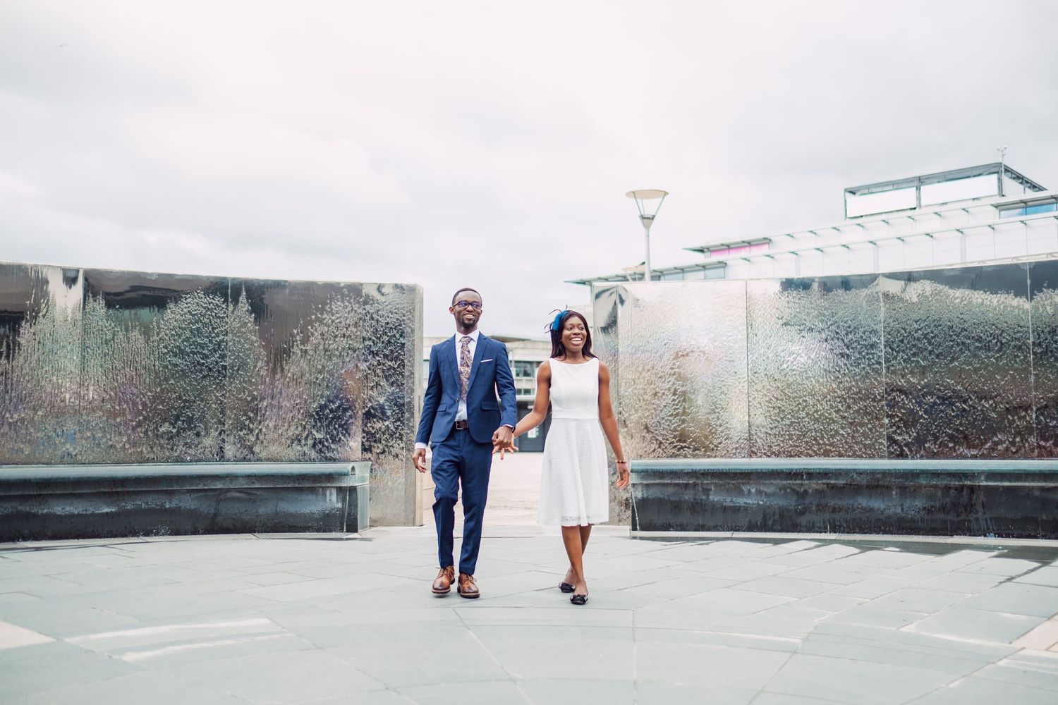 Couple walking together along a modern architectural pathway.
