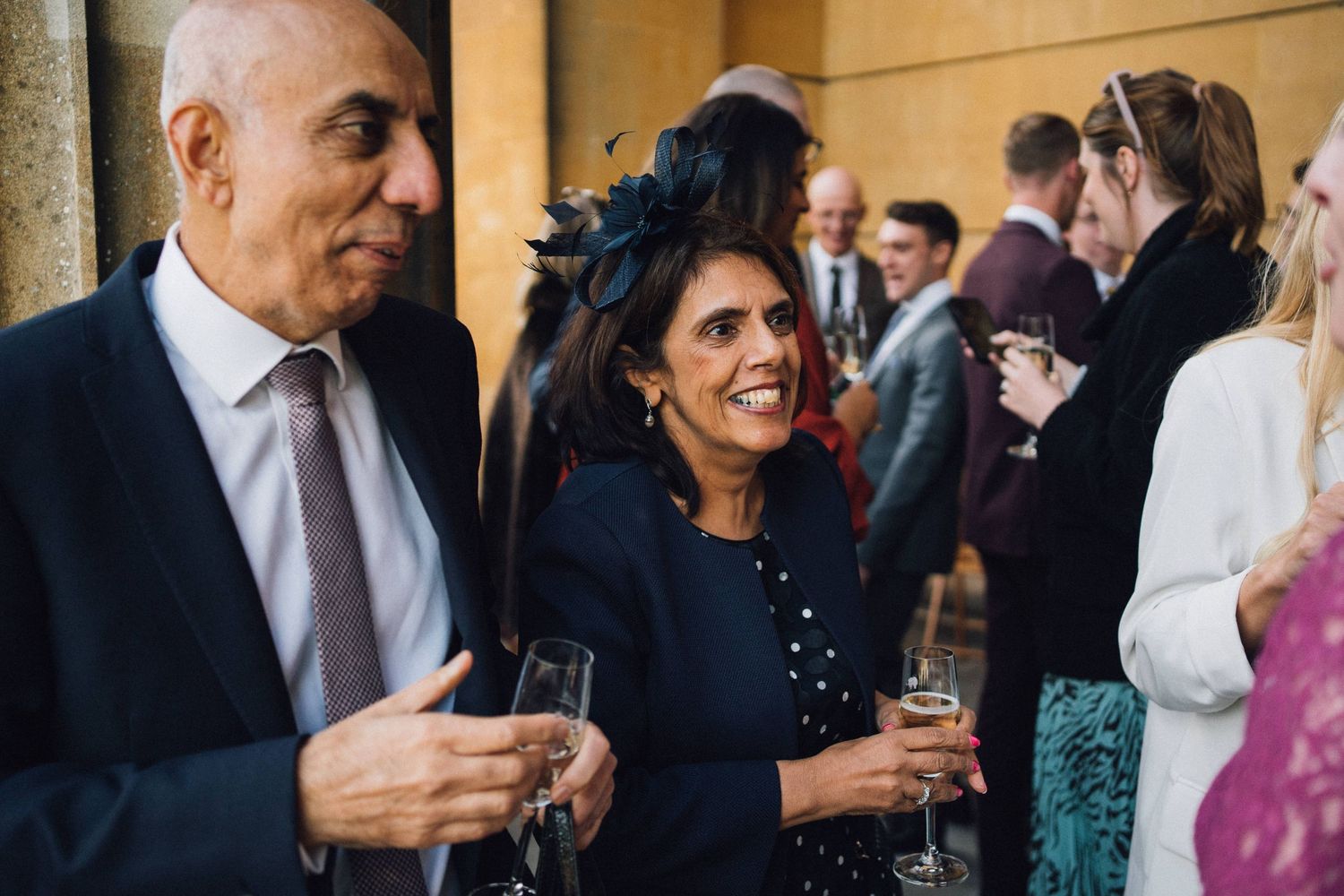 Wedding guests enjoying drinks and conversation during an elegant reception celebration.