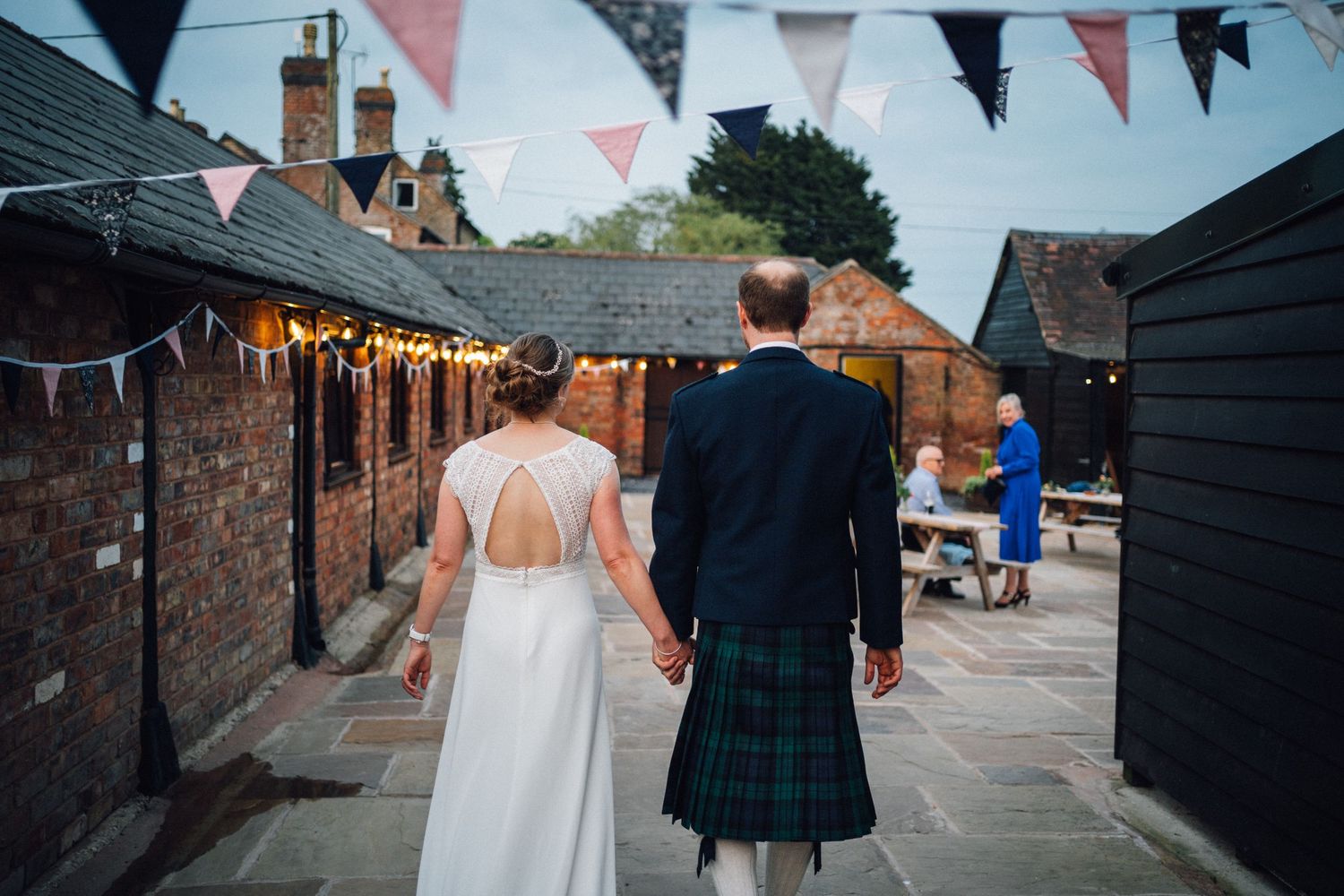 Wedding venue exterior decorated with red and white bunting flags against brick buildings.