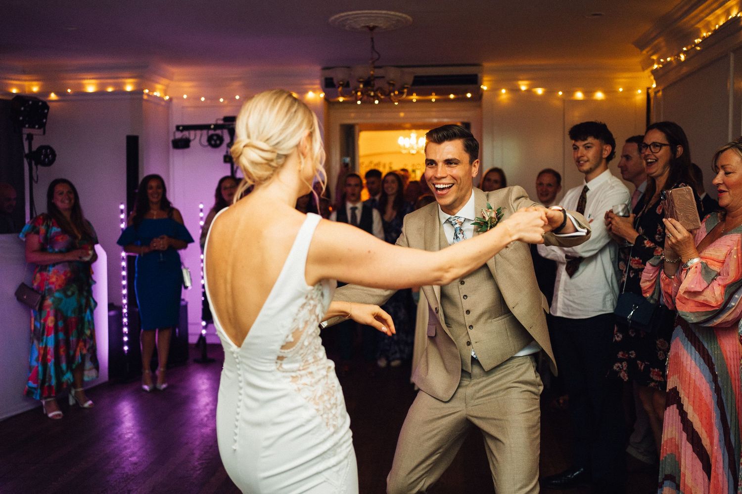 Wedding reception dance floor with purple lighting and string lights creating romantic ambiance.