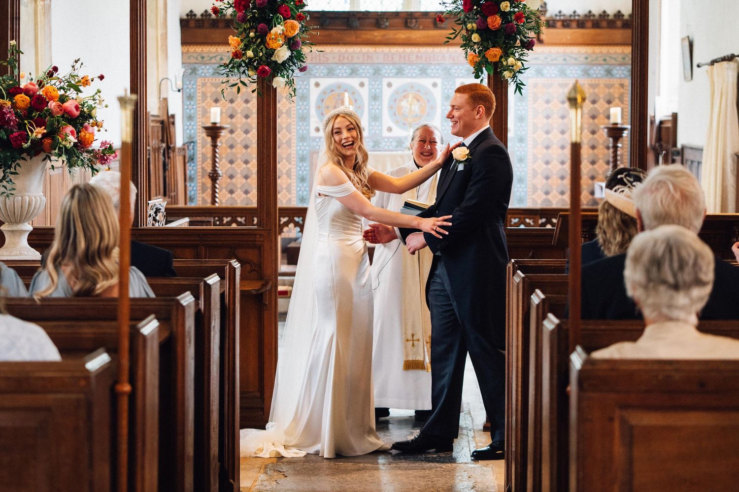 Couple sharing their first dance in a rustic venue decorated with colorful floral arrangements and wooden beams.