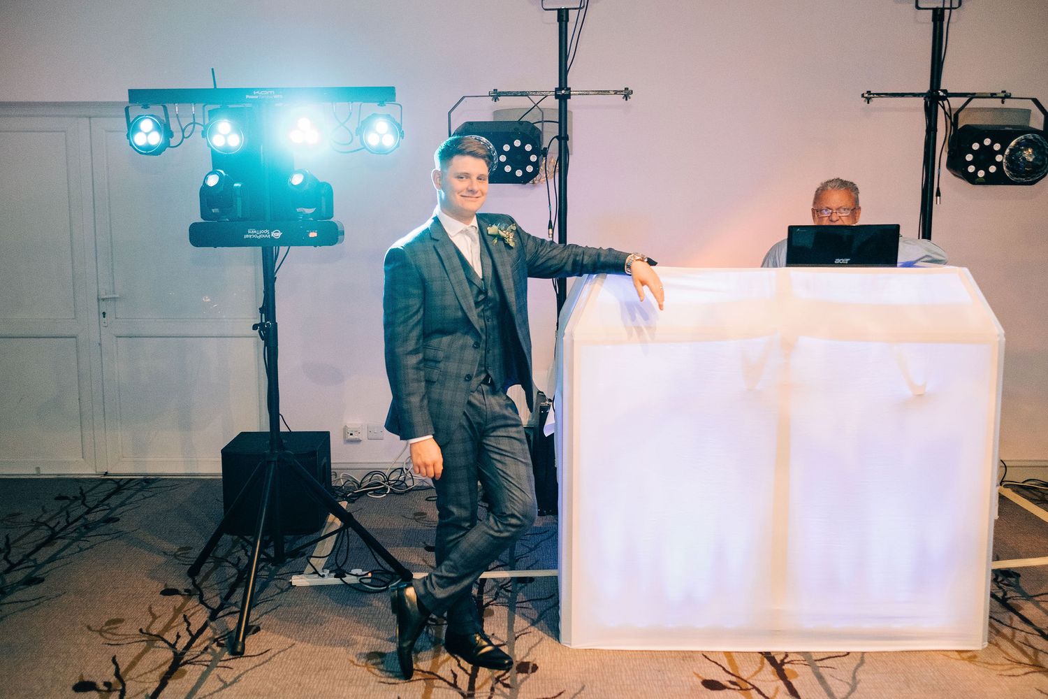 Professional lighting and DJ equipment setup at an indoor wedding reception venue.