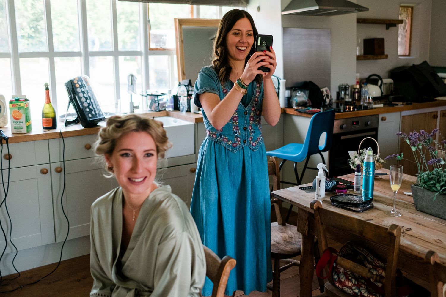 Wedding preparation scene in a kitchen with natural lighting and casual atmosphere.