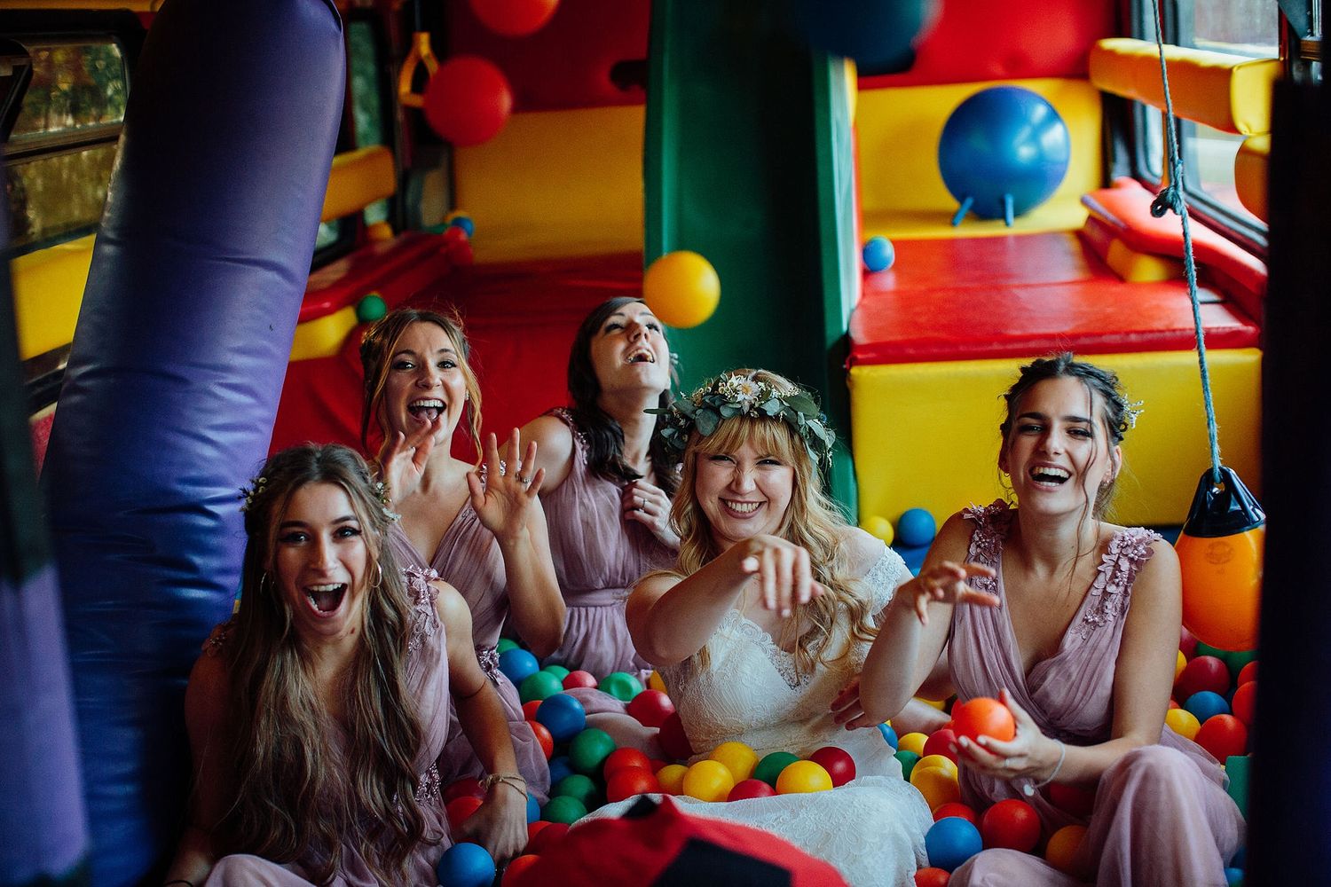 Kids having fun in a brightly colored indoor play area with balloons.