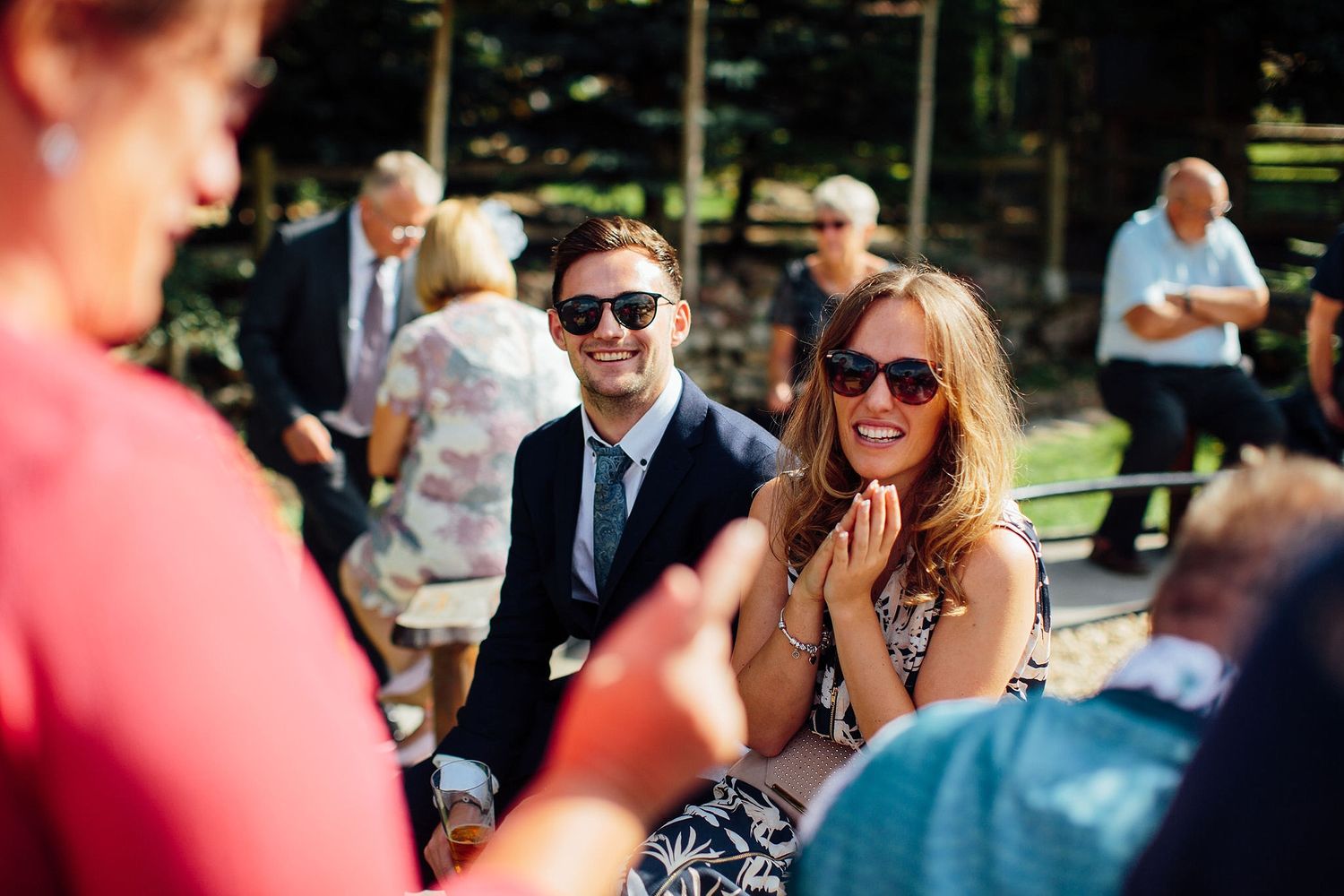 Wedding guests socializing and enjoying drinks at an outdoor reception.