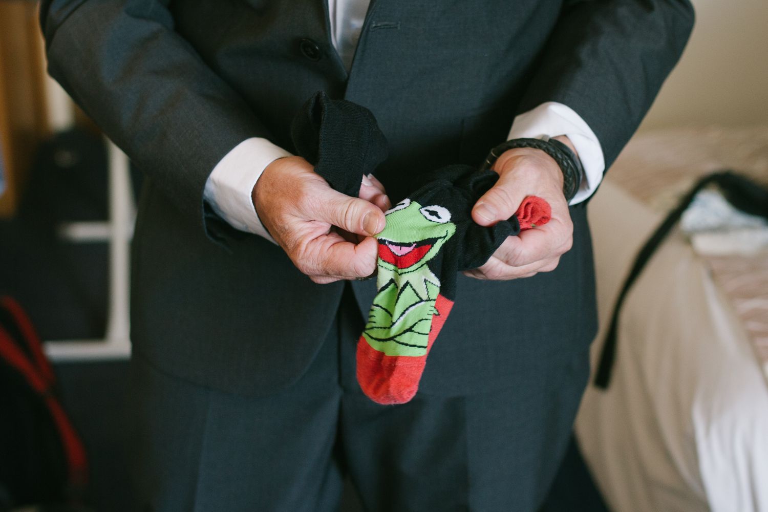 Person in formal suit holding colorful party favors.