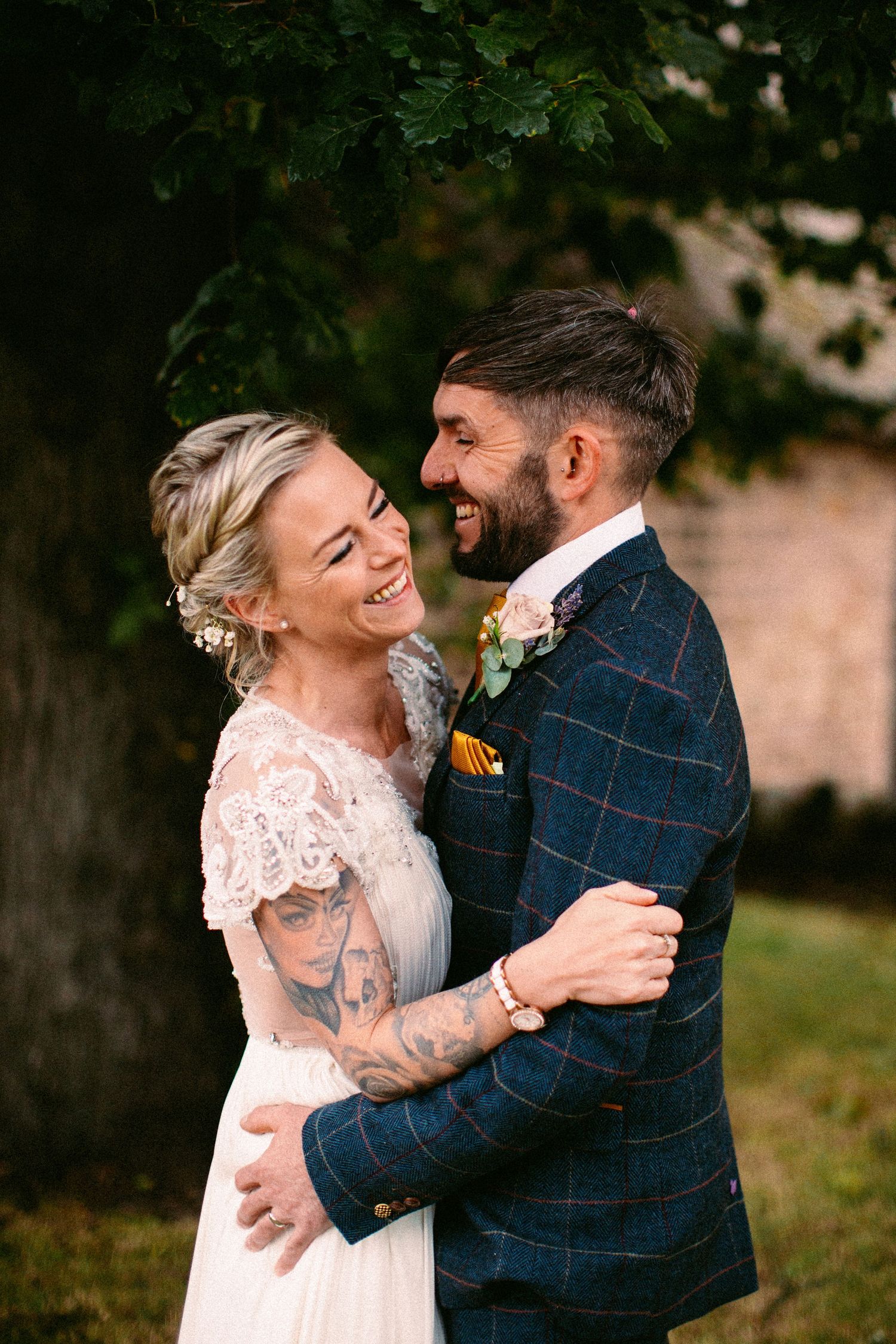 Natural wedding photography capturing genuine laughter and embraces in a garden setting.